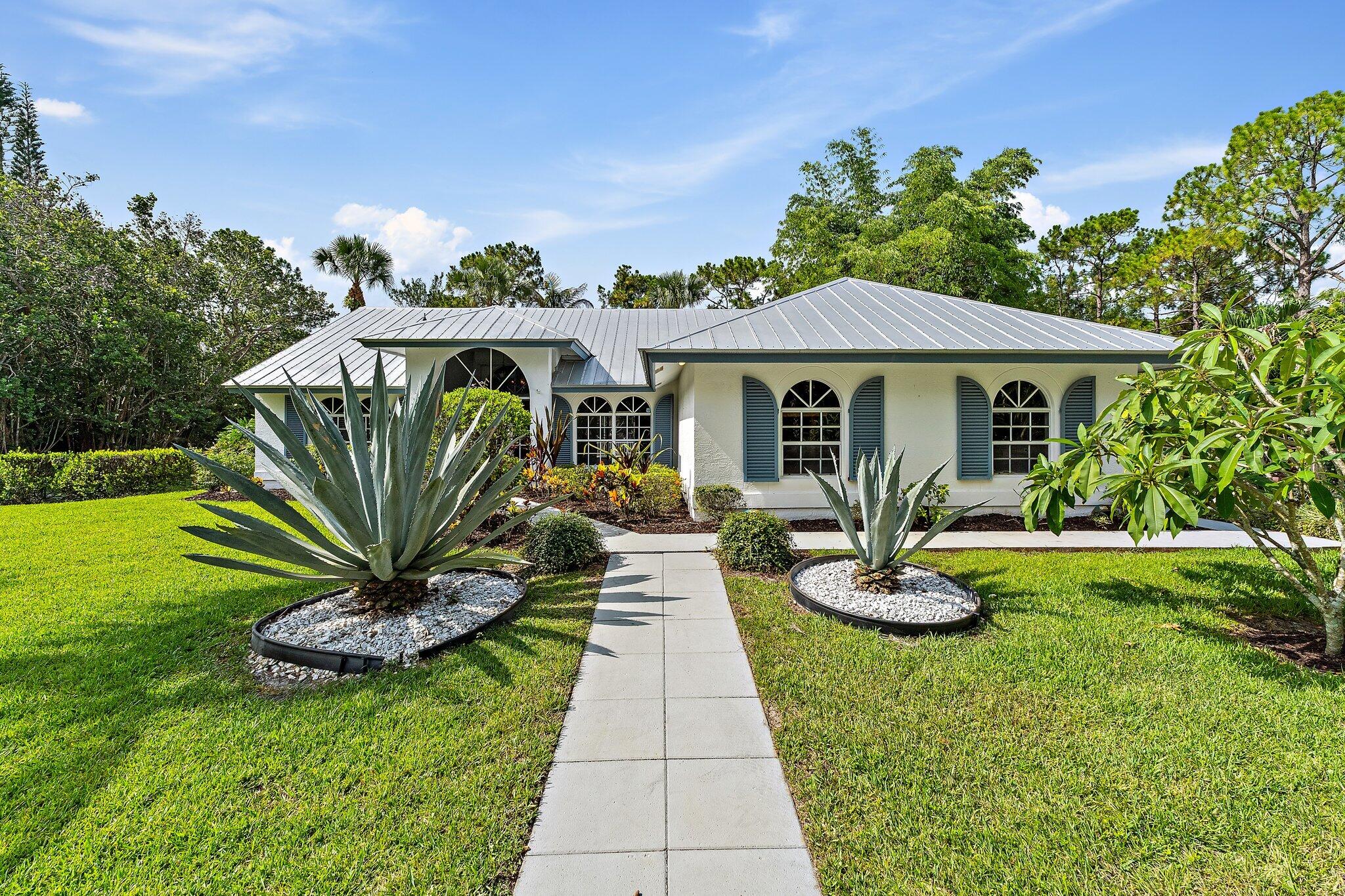 Three bedroom, two bath single-family home on 1.25 acres in Jupiter Farms, with no HOA, a saltwater pool, and room to park an RV or boat. The agricultural-residential zoning and 1.25-acre lot give you space, privacy, and freedom that most Jupiter neighborhoods cannot offer. The single-story layout runs 1,688 square feet under air with laminate and tile floors throughout. The living area opens to the kitchen and flows out to the screened pool. Three bedrooms and two full baths sit on one level, an easy floor plan for full-time living or a seasonal home. Outside is where this property earns its keep. The screened saltwater pool was updated with a salt system and multicolor LED lighting in 2023, and the screen enclosure was replaced in 2026. A brick paver patio sits near the canal at the back of the lot, framed by mature giant bamboo planted for privacy. The brick paver driveway is joined by a separate paver parking pad sized for an RV or a boat. Recent landscaping work in 2026 cleared and refreshed the grounds, and a crushed gravel drive was added the same year. Major systems: metal roof [2012 or 2013, confirm], A/C approximately 2021, electric water heater 2023. The home runs on well water and septic, with FPL electric service. Panel storm shutters for every window are included and stored in the garage. Central vacuum system in place. The lot backs to a preserve that gives the rear of the property a green, open buffer and a quiet, tucked-away feel. Jupiter Farms keeps you on acreage and close to nature while keeping the rest of Jupiter within easy reach. Riverbend Park and the Loxahatchee River are minutes away for paddling and trails, I-95 and the Turnpike are a straightforward drive, and the Jupiter beaches and Jupiter Inlet are roughly twenty to twenty-five minutes east. Zoned AR, so bring the toys, the trailer, and the projects.