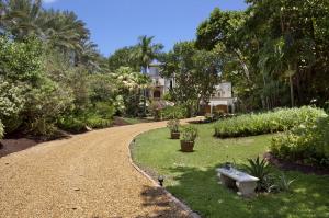 On the world-famous Hillsboro Mile, this gated Palm Beach-inspired villa is secluded in a lush Ocean-to-Intracoastal oasis featuring dune-fringed beachfront and private dockage.

From the gated entry, a long tree-canopied drive evokes a sense of serenity as it meanders through the tropical oasis of this Ocean-to-Intracoastal estate on Hillsboro Beach’s Hillsboro Mile, considered one of the world’s most exclusive addresses.  A romantic fountained entry greets guests at the stately six-bedroom Palm Beach-inspired villa in this idyllic seaside setting where vistas of the glistening blue ocean stretch to the horizon. Inside, the two-story atrium-like reception room centers on the ocean view through the sunlit living room where walls of French doors open to the magnificent oceanfront pool terrace, an amply sized outdoor entertaining space, caressed by the sea breeze amid swaying palm trees.  Ocean views also backdrop all of the other main living spaces in the airy atmosphere set off by white marble floors and washed-finish millwork.  Upstairs, the beautifully spacious master suite is surrounded by tranquil oceanfront vistas and opens to a full-length balcony.

The estate grounds have a private dune walkover that steps down to the beach, carpeted in sun-drenched sands.  On the Intracoastal Waterway, boat dockage in a no-wake zone is right near the Hillsboro Inlet on this prestigious stretch of the Gold Coast's barrier island.

Location
Hillsboro Mile, Hillsboro Beach, Florida.  The world-renowned Hillsboro Mile offers a scenic Old Florida setting in Hillsboro Beach, one of the Gold Coast's most beautiful communities.  Hillsboro Beach is centrally located only 9± miles south of Boca Raton and 13± miles north of Fort Lauderdale, placing world-class shopping, dining, entertainment, and sporting attractions within easy reach.

Property
Sumptuous tropical foliage surrounds this gated, 1.18±-acre Ocean-to-Intracoastal estate stretching from 112± feet of direct Atlantic Ocean beachfront to 122± feet on the Intracoastal Waterway with dockage in a no-wake zone just north of the inlet.  Glass doors open the ocean side of the residence to expansive terraces for large-scale outdoor entertaining by the resort-style pool and spillover spa edged in hand-painted tile.  An oceanfront lounge deck is by the dune walkway to the sands.

Residence
Capturing ocean views from nearly every room, this stately three-story villa provides six bedrooms, six full and two half baths, and a lower-level three-bay garage in a total of 8,462± square feet.  Amenities include an elevator and roll-down storm shutters.  White marble floors and washed-finish millwork give the interiors a light, airy look.

First Floor:  Palatial tracery-molded arched doors enter the marble foyer and striking double-height atrium-style reception room, wrapped with balconies around the upper level, centered on a beautiful tiled fountain.  Directly ahead, the oceanfront living room captures the glorious view through walls of arch-transomed French doors opening to the terrace.  A cross-beamed ceiling and baronial fireplace add the room's elegant finishing touches.  The hallway wet bar is centrally placed for easy entertaining.   Built-in bookcases line the inviting paneled library/den.  Opening to the terrace and oceanfront view, the formal dining room is served by the gourmet kitchen which shares the ocean view and has washed-finish cabinetry, a large island, and terra cotta tile flooring.  The oceanfront family room opens by the pool.  Two bedroom suites lead to a west-facing balcony.  A powder room completes this level.

Second Floor:  Ascending the turret-style staircase or elevator leads to the dramatic bridge hallway overlooking the reception room below.  Three window walls showcase the ocean view and tropical landscape in the expansive master suite which opens to a full-length covered balcony and features a wood-paneled peaked ceiling, wood flooring, and an inviting fireplace.  A walk-in closet and marble bath complete the suite.  Two more bedrooms, one with private balcony, also view the ocean.

Lower Level:  A wine room, powder room, and staff suite are provided on this level.