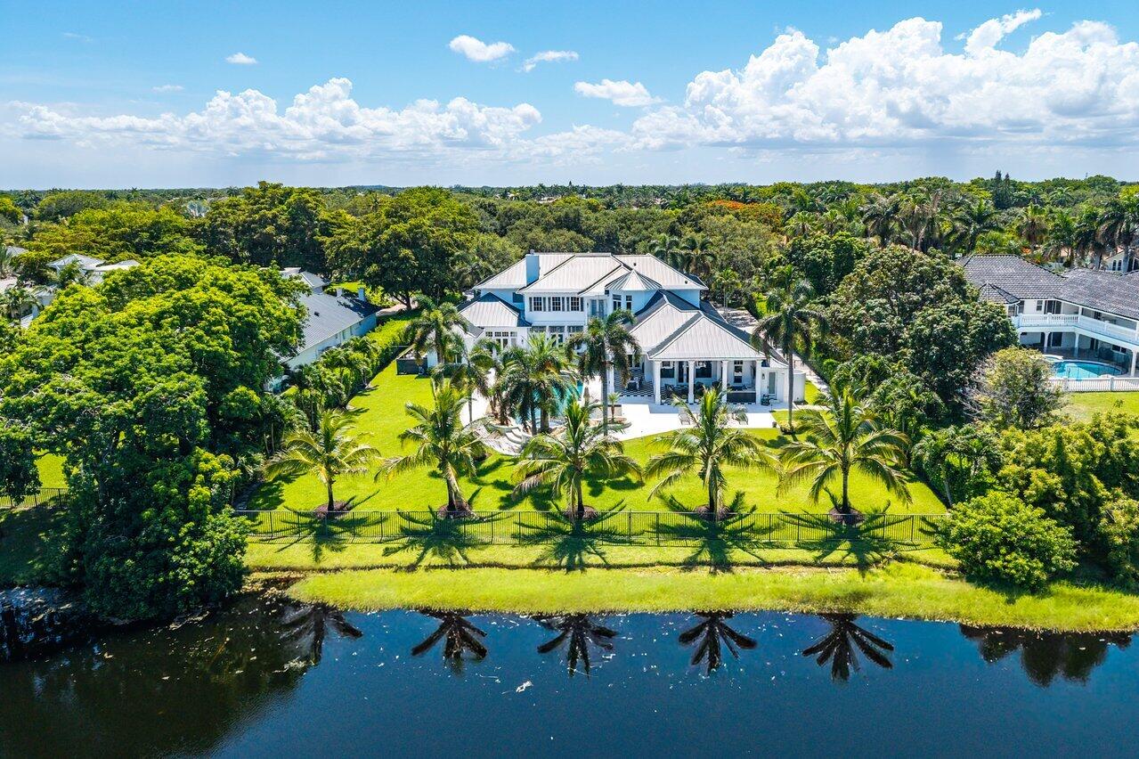 Situated on an expansive oversized lot, this exceptional 6 BD, 7 BA, 2 HB estate in Fieldbrook Estates offers an extraordinary blend of timeless elegance, grand scale, and effortless luxury, with remarkable spaces designed for both sophisticated entertaining and everyday comfort. A dramatic two-story foyer welcomes you into the formal living room, where soaring volume ceilings, a sweeping spiral staircase, and walls of windows fill the space with natural light. Just beyond, the formal dining room is adorned with exquisite coffered ceilings and expansive windows, creating a refined setting for memorable gatherings.  At the heart of the home, the beautifully updated chef's kitchen features paneled appliances, a walk-in pantry, an oversized center island, and peninsula seating overlooking the sunlit breakfast area. The adjoining family room seamlessly extends outdoors through French doors, creating an effortless indoor-outdoor lifestyle. The resort-inspired primary suite is a true private sanctuary, complete with its own fitness room, French doors opening to the pool, dual spa-inspired bathrooms, and two oversized walk-in closets. The first floor also features a private office, an ensuite guest room with cabana bath access that also functions beautifully as a den or billiards room, and an additional ensuite bedroom. Upstairs, two spacious bedroom suites each offer a private balcony, walk-in closet, ensuite bath, and an adjoining bonus room currently configured as a vanity and office. An expansive entertainment suite with an additional flex room, private balcony, walk-in closet, and ensuite bath presents endless possibilities as a home theater, game room, lounge, or private guest retreat, while an additional ensuite bedroom completes the second level. The spectacular backyard is a true resort-caliber escape, thoughtfully designed for year-round enjoyment with a sparkling pool and spa, an expansive covered patio complete with a summer kitchen and TV, a putting green, sprawling green space, and lush tropical landscaping, all perfectly positioned to capture tranquil lake views and create the ultimate private outdoor retreat.