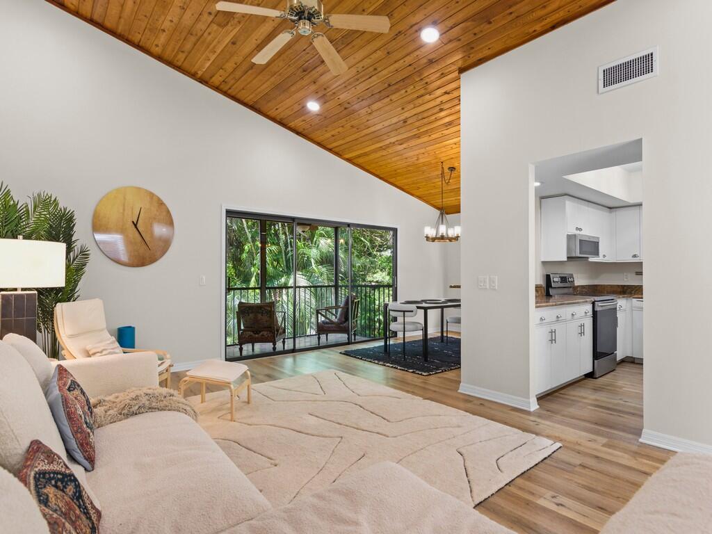 Welcome to your Tropical Florida Paradise! This beautifully maintained 1,433 sq ft end-unit condo features a 2023 A/C, 2020 roof, 2023 exterior paint, remodeled primary bathroom and walk-in closet, luxury vinyl plank flooring, granite kitchen countertops, vaulted 14-ft ceilings, and recessed lighting. The private staircase, windows on all four sides, and lush greenery create a bright and peaceful setting. Affectionately known as "Treehouses" by residents, this unique community offers convenience just 6 minutes to I-95, 7 minutes to shopping, and 20 minutes to the beach. Welcome home!
