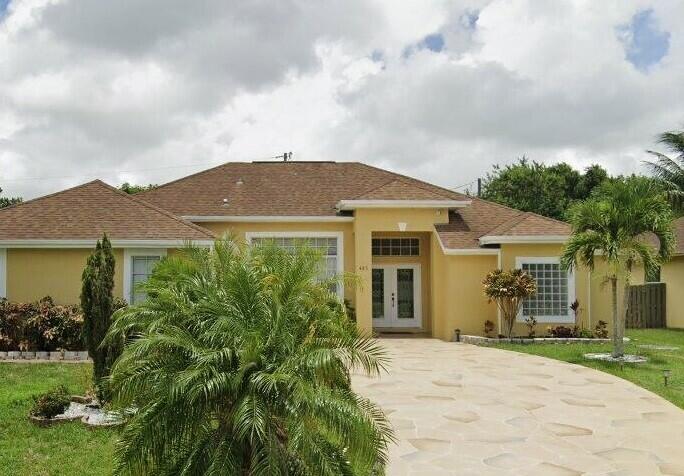 Come make this 4-bedroom, 2-bathroom, open concept home in the highly desired area of Port St. Lucie your home. Located close to both the I-95 and the turnpike, schools, churches, parks, shops and restaurants. The home is spacious, w/large glass double entry door, high ceilings, custom built-in wall units. The main living room features a double wide sliding glass backdoor; The kitchen has flat-top stove, built-in double oven, custom built 48" cabinetry; On the far side of this split planned home are 3 nicely sized rooms. The other side of the home is the master suite. His and her closets and a sliding glass door with direct access to the patio; The master bath features his and her sinks on opposite sides of the room, a standalone shower and an alluring roman tub.
