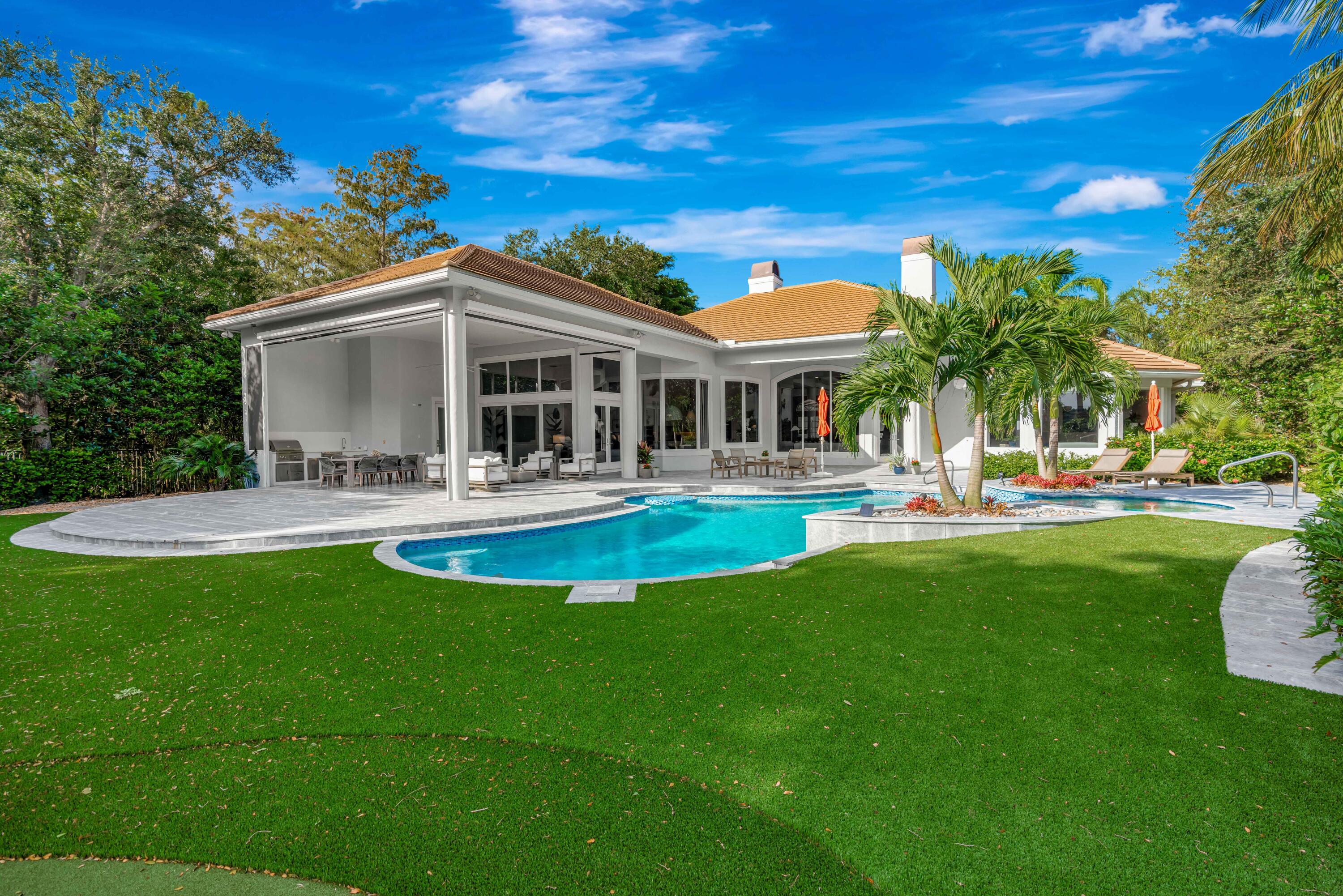 Discover refined living in the exclusive gated golf community of Old Marsh. Perfectly positioned on ¾ of an acre with stunning eastern-facing views, this 5,000 sq. ft., 4-bedroom residence has been fully renovated and move-in ready.  Step inside to fresh new flooring that creates a warm California-inspired vibe, while outdoors, a brand-new summer kitchen with phantom screens sets the stage for effortless entertaining. The home's private setting is enhanced by preserve on one side and lush tropical landscaping throughout, creating a serene retreat.  Enjoy the convenience of a low-maintenance artificial turf yard complete with a putting green, perfect for both fun and relaxation.  As a resident of Old Marsh Golf Club, you'll experience one of South Florida's most coveted - more...