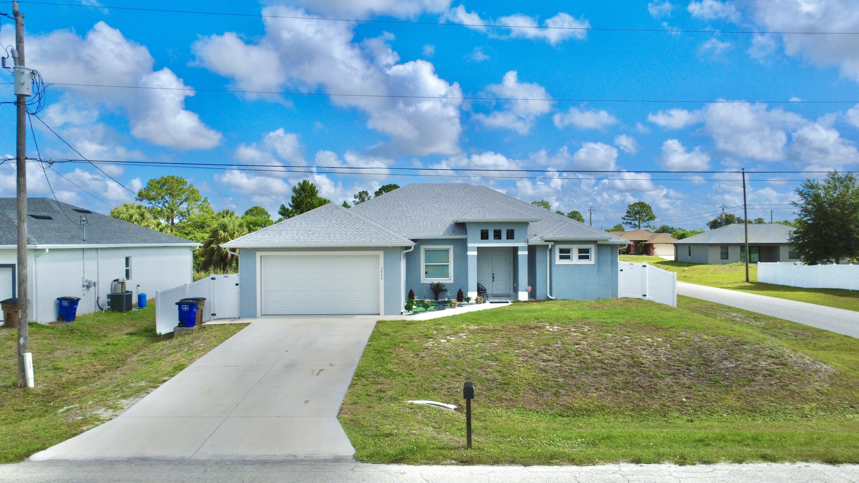 Experience affordable luxury in this exceptional 2022 custom built residence located in the heart of Lehigh Acres. Boasting over 2,300 square feet of elegant living space, this stunning property offers 4 spacious bedrooms, 3 beautifully designed bathrooms, and a private mother in law suite perfect for guests or multigenerational living.Situated on a fully fenced corner lot, this home welcomes you with soaring ceilings, modern finishes, and an impressive open concept layout designed for both comfort and sophistication. The open style kitchen seamlessly connects to the expansive living and dining areas, creating the perfect atmosphere for entertaining and everyday luxury living. The primary suite is a private retreat, featuring generous space and a spa inspired bathroom designed for  relaxation. The two additional bedroom and bathroom has been thoughtfully crafted with modern elegance and functionality in mind. Step outside to a spacious backyard with endless possibilities , design your dream pool, create a tropical outdoor oasis, or simply enjoy the peace and privacy this property offers.Combining style, space, and versatility, this remarkable home delivers the perfect blend of luxury and convenience. Don't miss the opportunity to own one of Lehigh Acres' most impressive homes. Schedule your private showing today.