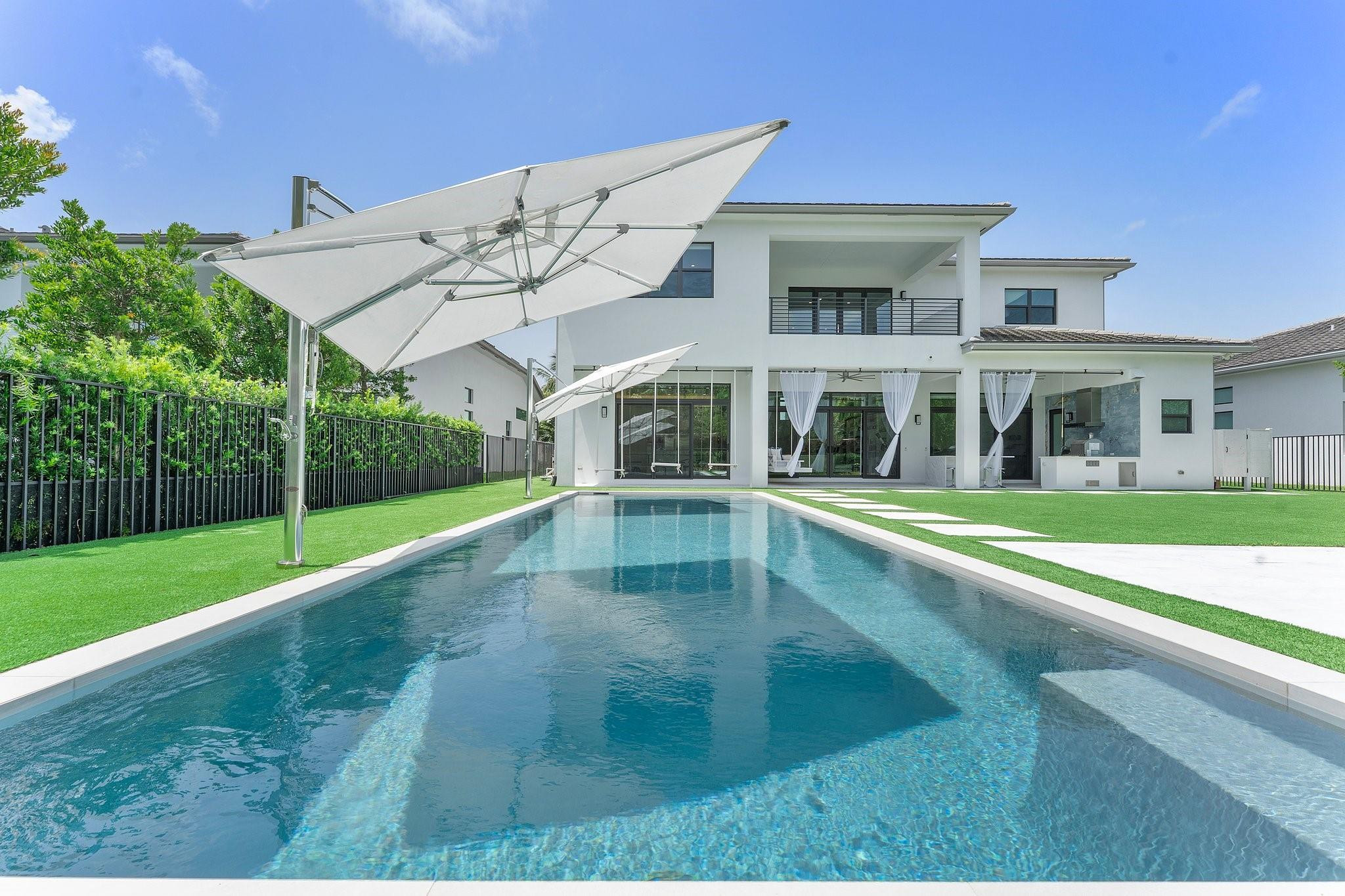 Discover elevated living at 9626 Vescovato Way in Boca Bridges—an exquisitely upgraded residence with over $443,000 in enhancements. This turnkey home blends timeless design with smart technology, featuring a glass-enclosed loft, designer lighting, a reimagined club room, and a chef’s kitchen with granite counters and Moroccan-inspired LED backsplash. Outdoors, enjoy a $120K custom pool, spa-style shower, summer kitchen, and lush turf with suspended daybeds and Tuuci umbrellas. Both garages include AC, with one converted into a private fitness studio. Residents enjoy a world-class clubhouse, gourmet dining, spa, resort pool, and elite tennis and pickleball facilities in Boca Raton’s premier gated community.