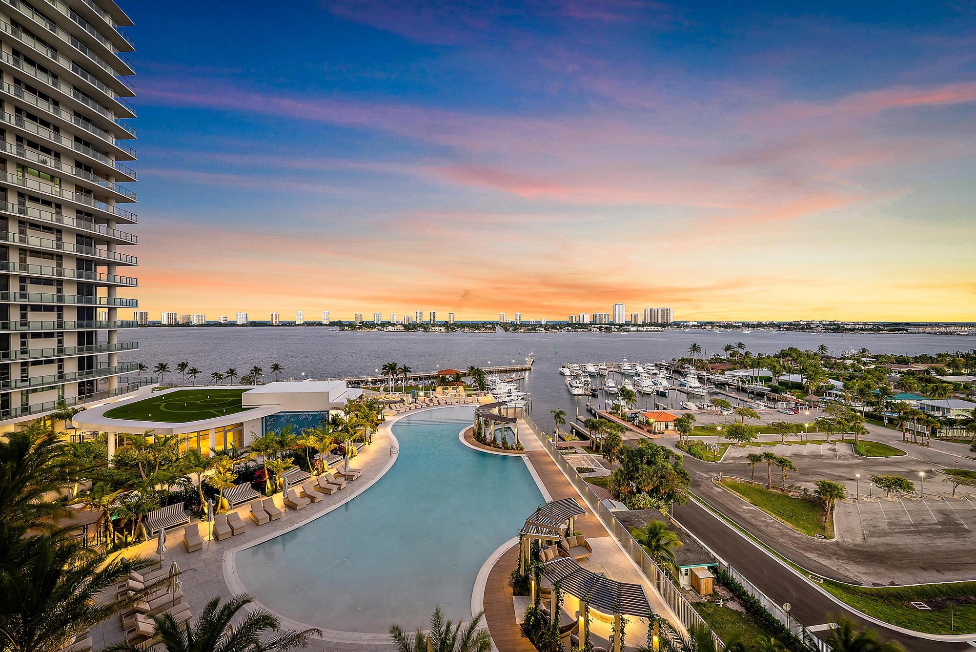 Rare dual water views and effortless waterfront living at Nautilus 220. This high-floor 3BR/3.5BA plus den residence captures sweeping Intracoastal vistas by day and Atlantic sunrises beyond, creating a unique front-to-back water experience rarely found in South Florida condominiums. Floor-to-ceiling glass, Stephen G interiors, Miele appliances, newly installed integrated motorized shades, and refined European finishes deliver a truly turnkey ownership experience. Positioned within Lake Park's emerging marina corridor just north of Palm Beach, this newly built residence offers convenient access to waterfront dining, marinas, and a rapidly evolving waterfront district. Designed for full-time, seasonal, or lock-and-leave ownership, Nautilus 220 offers a rare opportunity to secure high-floor  Amenities at Nautilus 220 rival a private waterfront resort. A sprawling one-acre amenity deck features a resort-style pool and spa, fire pits, putting green, yoga lawn, and dog park, complemented by a club room, cinema, golf simulator, valet, and 24-hour concierge. Wellness and recreation continue indoors with a spin studio, fitness facilities, billiards and card lounge, kids' playroom, and teen gaming space. The rooftop lap pool and spa offer panoramic views spanning the Intracoastal and Atlantic. Additional conveniences include 24-hour security, on-site management, electric vehicle charging, and private marina access. Waterfront dining, boutique retail, office space, and a café are seamlessly integrated into the community, creating a walkable waterfront environment designed for effortless luxury living and lock-and-leave ownership.