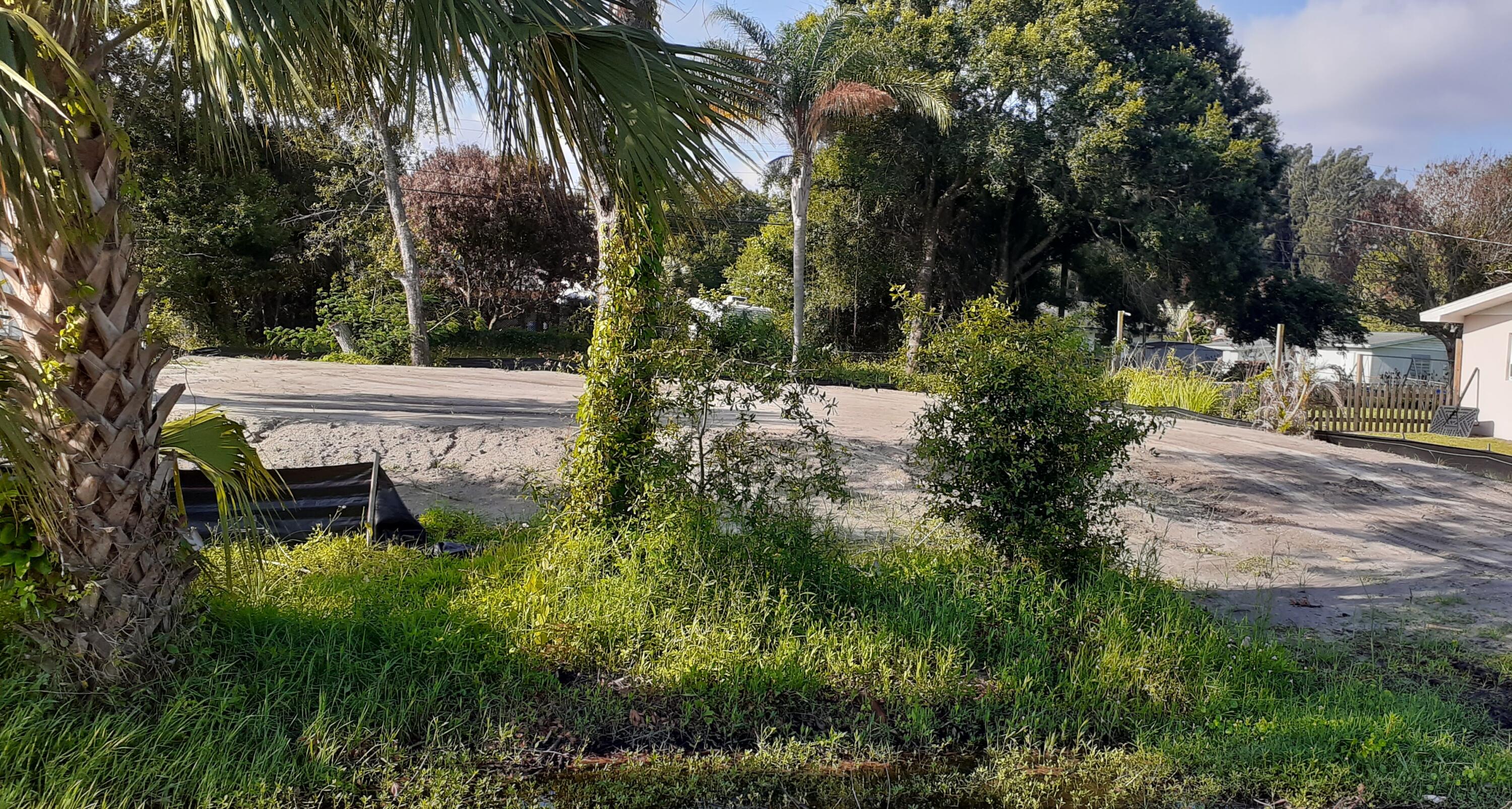 Cleared and filled lot ready for a new home, silt fence in place, plans available for custom designed 1433 sq ft., 3 bedroom 2 bath 2 car garage home with previous building permit issued. Some nice trees left around perimeter, oak and palm.  Fill dirt brought in for building compliance along with compaction test done including engineering letter of compliance. Driveway culvert in place. City water and sewer with annexation to city when connected. Trusses partially paid in advance, impact fees paid.  Lovely centrally located neighborhood. Ready for your dream home today or for future investment.
