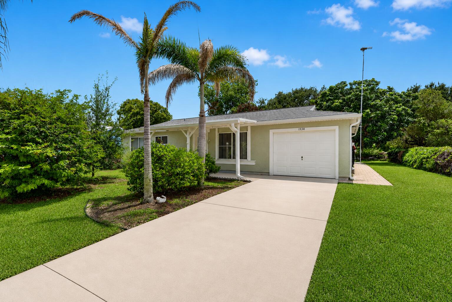 Discover a gardener's paradise with NO HOA! Lovingly maintained by a passionate gardener, this beautifully landscaped property showcases rare tropical plants and fruit trees. Enjoy exceptional privacy with a City of Port St. Lucie green space and nearby pond behind the home—no future rear neighbors. The neighborhood also features underground electric and cable. Major updates include a 2012 kitchen remodel with oak cabinets, granite countertops, and tile flooring throughout; a new roof with Peel & Stick underlayment, Hardie board siding, and gutters (2018); updated bathroom, Moen fixtures, and stainless steel appliances (2019); and a new HVAC system (2020). Conveniently located minutes from Crosstown Parkway, I-95, the Turnpike, shopping, and beautiful Treasure Coast beaches.