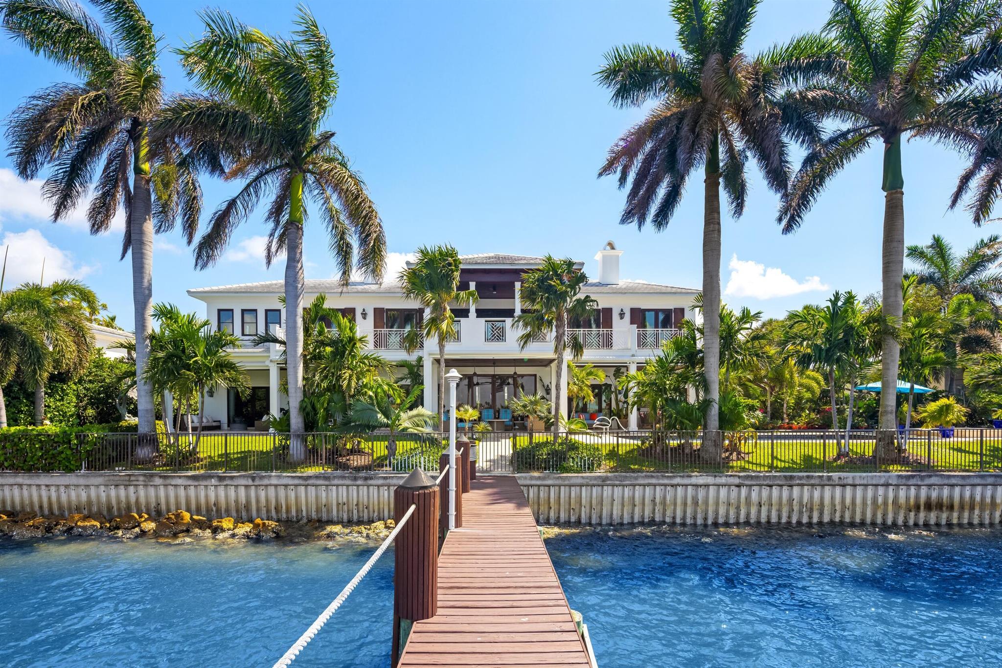Stunning British Colonial estate in serene Point Manalapan. This elegant and inviting 5BR/5.2BA home is situated on a fantastic, lakefront lot and features breathtaking views of the Intracoastal. Gracious floorplan with welcoming, double height reception room, formal dining room, and spacious great room. Gourmet kitchen with large island, top-of-the-line appliances, and butler's pantry. Expansive primary wing complete with sitting area, dual walk-in closets, large bath with dual vanities, and fabulous covered balcony with stunning water views. Gorgeous outdoor spaces with covered loggia that spans the entire back of the home, summer kitchen, pool with spa, and lush tropical landscaping giving the home a relaxing, resort-style feel. Private boat dock with lifts, perfect for the avid boater Additional highlights include elevator, first and second floor laundry rooms, upstairs living area, and 3-car garage.