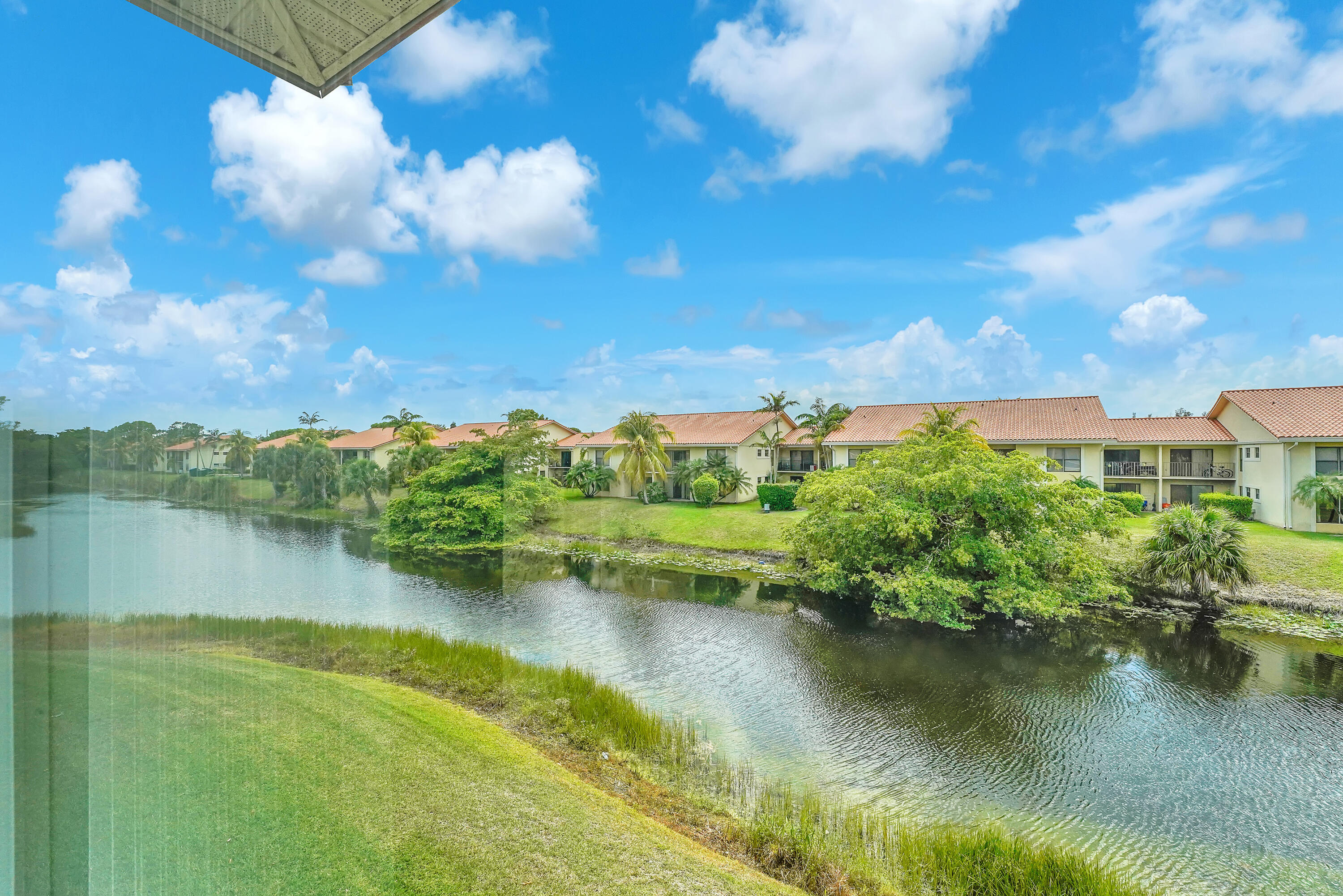 Fully Furnished, move-in ready, turn-key,  2-bedroom, 2-bath waterfront condo on the 2nd floor (walk-up) complete with an enclosed Florida Room—perfect for relaxing with a view. Step inside to find an updated beautifully decorated unit with spacious walk-in closets in both bedrooms. A true benefit: an in-unit laundry room with full-size washer and dryer for your convenience! This vibrant, guard gated  55+ community offers resort-style amenities, including fitness center, tennis, lakefront pools, and a courtesy shuttle bus, with a calendar full of activities to keep you engaged. Ideally located near shopping, dining, beaches, entertainment, I-95, the Florida Turnpike and DJT International (PBI) airport.