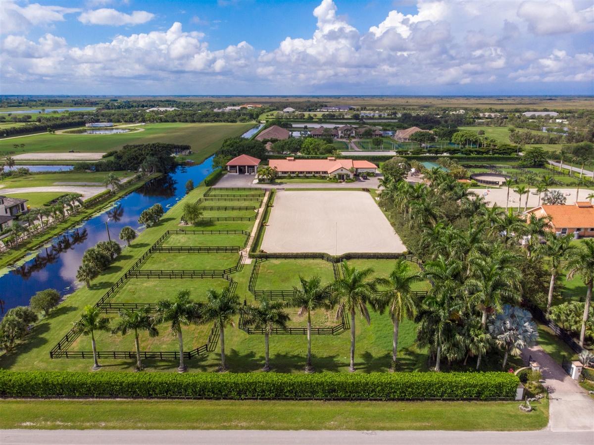 Location, Location! This Palm Beach Point East equestrian property has it all. Situated on 5 acres with 2 barns and 23 stalls this is a real horseman's property with a solid rental history. Mature landscaping with a canopy tree driveway leads you to the barns with ample parking. There are 2 air conditioned tack rooms & feed room accompanied by a riders lounge, bathroom and 2 sets of washer/dryers, 4 grooming stalls and 4 wash stalls. Both barns have complete fly systems, fans, and comfort stalls in main barn. The 132' x 270 riding arena with GGT footing is graced by a comfortable viewing area. The 9 large irrigated paddocks have privacy hedges. The owner/staff quarters includes 3 bedrooms, 1 bathroom, full kitchen with dining and living areas. There are 2 additional buildings for hay, shavings and storage. The 1 RV hookup give you added flexibility. A must see property!