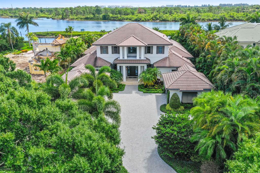 Pinnacle of ICW living, prime location, more than half an acre on direct Intracoastal uniquely protected by a barrier island (no wakes), with an unobstructed view to ICW and nature preserve. Located on prestigious Commodore Island. Home built in 2014 and meticulously maintained, focuses on casual living with top quality and low maintenance materials that blend into large open spaces perfect for family gatherings and entertaining. 4 bedrooms plus office and media room/loft, 4 car garage (3 are AC'd). Beautiful ceiling details, impact windows, wood and marble flooring, Owner's private wing with paneled study facing ICW, master bedroom with breakfast bar, gorgeous views, huge closets, and a large take me away bath with his and her toilet rooms. The kitchen features 6 burner Wolf gas stove... Wolf steamer/convection oven, oversized quartzite kitchen island with breakfast bar, Sub Zero fridge and separate freezer, Shaw's Original apron sink, wet bar, and wine storage. The family room merges with expansive covered logia for relaxed indoor/outdoor living. Logia has phantom screens and electric shutters, steps from your edgeless swimming pool, with a large sun shelf, and hot tub. The summer kitchen completes the fun. Your yacht (up to 70') awaits on the private dock with 18,000 lb boat lift. 

Required golf membership purchase conveys all the first-class amenities of Admirals Cove including two spectacular clubhouses, 45 holes of golf, 5 restaurants, 58 slip marina with floating docks, Yacht Club, 11 har tru tennis courts, 5 pickleball courts, state of the art fitness, 21,000 sq ft brand new spa & salon, Covesters kids club and Platinum service.