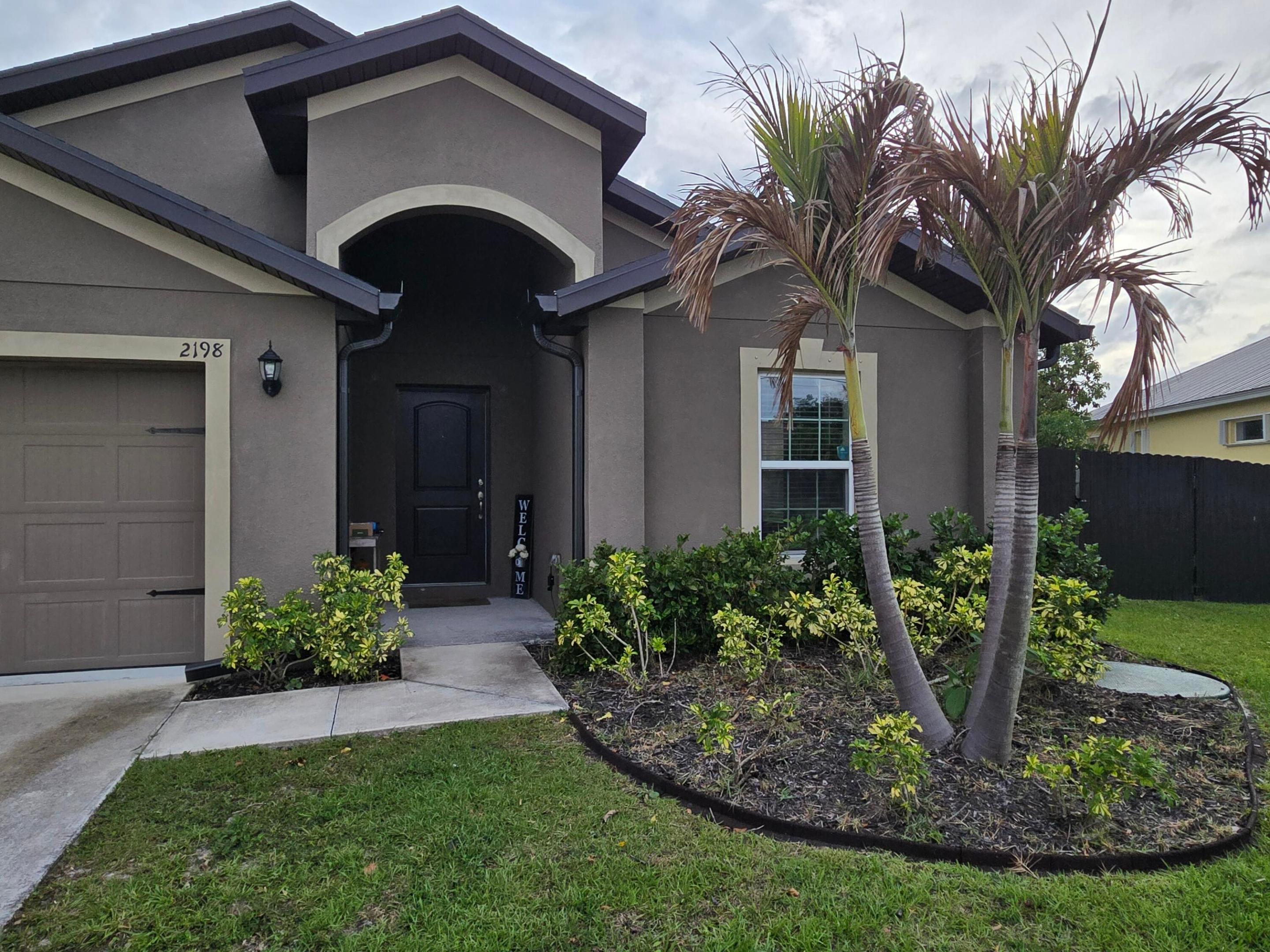 Situated on an oversized corner lot in Port St. Lucie, this property offers exceptional outdoor space, privacy, and functionality. The fully fenced yard features a new aluminum fence installed in 2023. A 50-foot driveway extension and dedicated pad with gated access, completed in 2024, provide ideal space for RV or boat storage. The home also features an 800 sq ft covered patio built in 2025, including 500 sq ft screened, creating a perfect setup for year-round outdoor living and entertaining. A fully paid $30,000 solar system installed in 2023 with a 25-year warranty significantly reduces electric costs, and an FPL EV charger is installed in the garage. A new well and sprinkler system (2023) support efficient irrigation. Conveniently located near major roads, shopping, and dining.