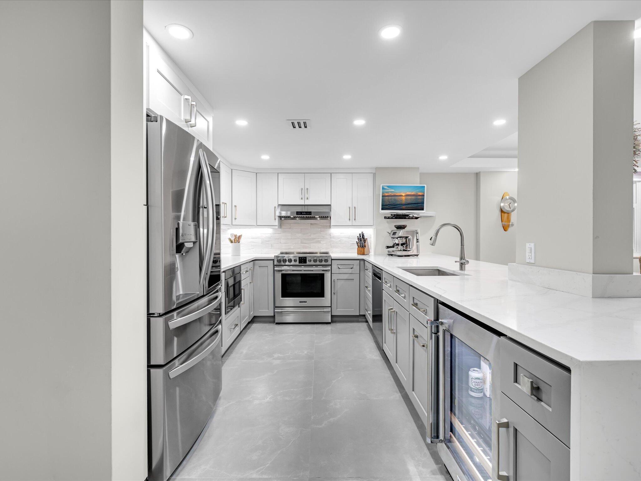 Please take the time to look at every photo, you'll be speechless. Ideally situated along the prestigious Hillsboro Mile, this one-of-a-kind 2-bedroom, 2-bath wrap-around CORNER UNIT has been meticulously renovated from top to bottom.  Approx $175,000 has been invested in high-end renovations and finishes, top of the line appliances, including an in-unit WASHER AND DRYER, full Impact Glass throughout, newer AC and water heater.  The state-of-the-art kitchen showcases sleek quartz countertops and custom cabinetry, seamlessly blending modern design w/ everyday functionality.  Contemporary fixtures throughout enhance the home's appeal, delivering the perfect balance of style and comfort.  There are 5 flat screen TV's in the unit that will convey with the sale of this beautiful condo. Residents will also appreciate some of the lowest condo fees along the coast at just $1,044 per month, along with the peace of mind of fully funded reserves and all special assessments to be paid in full by the seller. Additional highlights include private beach access and Intracoastal front pool—completing this exceptional coastal offering.