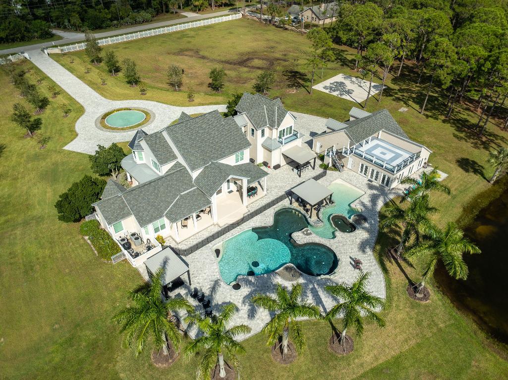 Welcome to one of the most iconic estates in the region the famed ''Mickey Mouse House'' a fully renovated 18-acre luxury retreat offering over 7,500 sq ft of resort-style living. Perched above a true destination-level pool and a serene 5-acre private lake, this property delivers an unmatched lifestyle of beauty, privacy, and pure fun. From the moment you enter, the home feels like a five-star getaway. The main house features 4 spacious bedrooms, a dedicated office, an elegant library, and a professional-grade movie theater. The heart of the home is the expansive, light-filled kitchen with open sightlines to the living areas, soaring ceilings, and custom live-edge wood accents that create a warm, organic sophistication. A covered bridge leads to a full in-law suite, kitchen, bath.