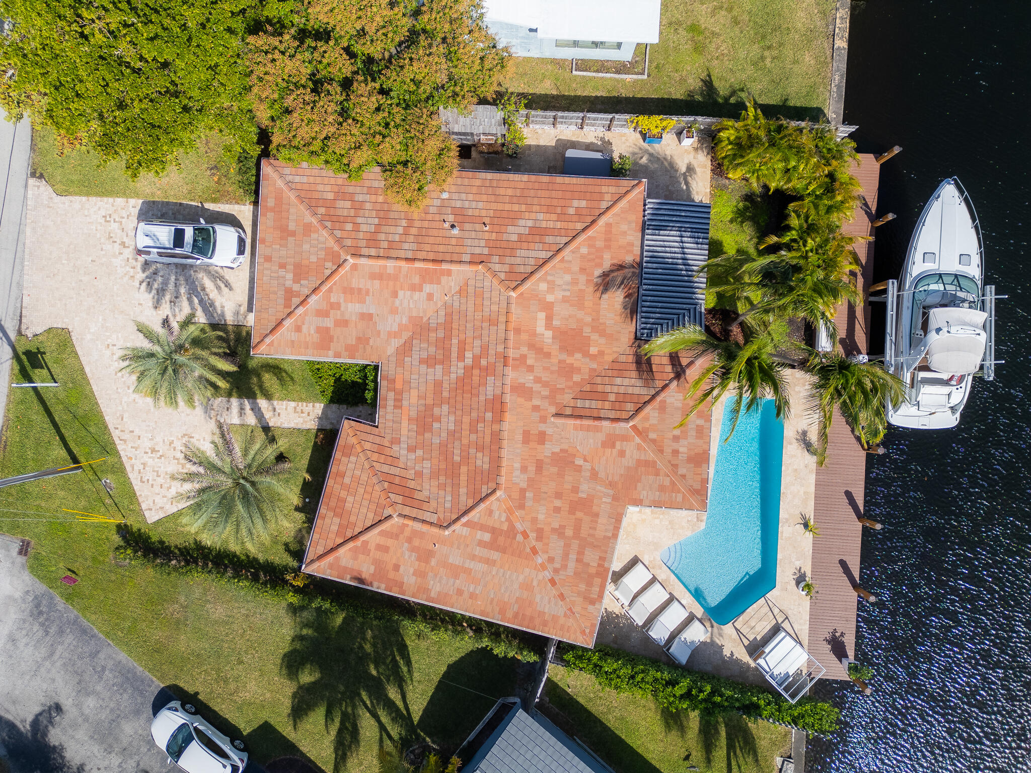 Boater's paradise awaits in this stunning East Wilton Manors home! With 80 feet of canal and dock frontage, plus an electric boat lift, there's room for all your water toys. Step outside to your heated pool, perfectly positioned to overlook the serene waterfront. A covered, landscaped patio provides privacy and shade, while a tucked-away hot tub and outdoor shower add luxurious touches. Inside, the open-concept living, dining, and kitchen area shines with a central island and sleek overhead exhaust. Renovated over the last five years, the home boasts contemporary baths, including a spa-like primary bath with a full-body shower. Impact windows, including a wall of sliders, seamlessly connect indoor and outdoor spaces. Travertine marble finishes!  New roof 2018 All new hurricane doors / windows All the marble hardscape New dock 2019 New 15k boat lift 2019 All pipes under house replaced 2024 All new electrical 2019 including instant hwh