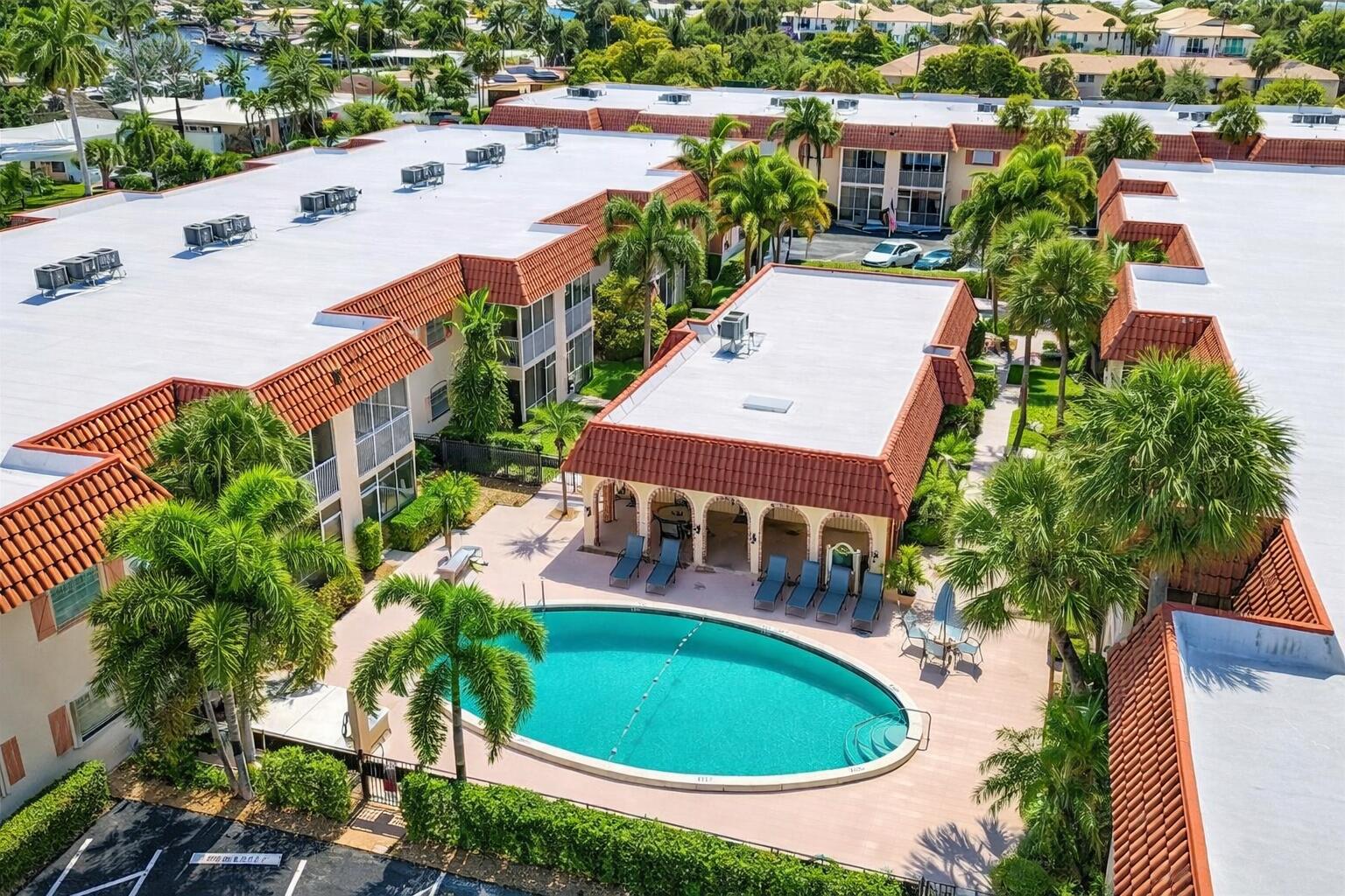 Welcome to Barcelona Gardens, a hidden gem in the heart of Pompano Beach! This beautifully maintained 1-bedroom, 1-bathroom first-floor condo offers the perfect blend of comfort, convenience, and coastal living. Step inside to find a bright and inviting layout that flows seamlessly to your own private screened-in balcony ideal for morning coffee or unwinding after a day at the beach.  Soft close high end driftwood kitchen cabinets with stone look backsplash and a kitchen island. Stainless steel appliances. Plantation shutters in bedroom. Beautiful wood plank ceramic tile flooring. Large walk in closet. Professionally decorated by Sunny Days Interiors. Impact windows/slider. Spacious storage closet on patio. Located just minutes from the pristine shores of Pompano Beach, this home places you right where you want to be. Spend your weekends soaking up the sun, dining at waterfront restaurants, or exploring nearby shopping and entertainment. With easy access to major highways, commuting to Fort Lauderdale or even Miami is effortless.  Making this an ideal full time residence, seasonal retreat or investment opportunity. Barcelona Gardens offers a well kept community a sparkling pool, clubhouse, assigned parking, and conveniently located free laundry facilities. The low HOA fee includes water, adding even more value. Plus, it's pet-friendly so your furry companion is welcome too!  Free laundry steps from your door!! Patio & building painting coming soon assessment paid in full. Whether you're a local buyer looking for a low-maintenance coastal lifestyle or an out-of-town buyer dreaming of a sunny South Florida getaway, this condo checks all the boxes. Don't miss your chance to own a slice of paradise just minutes from the beach!