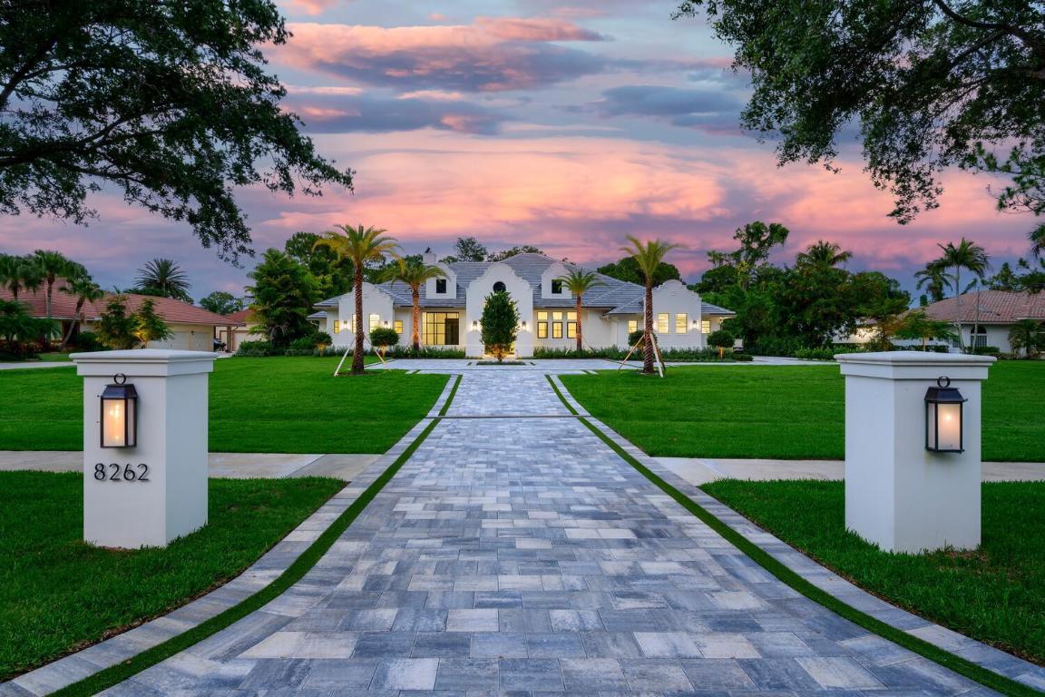 Introducing a meticulously planned new construction estate built by Chris Allen Homes and Yates Architects, in the prestigious gated community of Steeplechase in Palm Beach Gardens. Sitting on an acre, this luxurious estate offers 5,085 square feet of living space, spanning over 7,400 square feet total. The open layout and split floor plan include 5 bedrooms, 4 full bathrooms, powder room, cabana bath, den, salt-chlorinated pool, 2 wood burning fireplaces, walk-in closets throughout, and an oversized 4-car garage. Easy Access to I-95 and Turnpike, Restaurants, Shops, Renowned Golf Courses, Pristine Beaches and so much more! Full Set of House Plans, Survey, and Virtual Walkthrough available for viewing. See Supplemental Remarks for additional information. The extended paved driveway leads you to a sleek 10' impact glass front door. Upon entering the grand foyer, you are greeted by timeless matte porcelain tile checkerboard flooring, 14'foot tray ceilings, and a designer chandelier, transitioning seamlessly to the elevated engineered oak wood flooring in the main living area. The great room showcases 14-foot coffered ceilings, an elegantly designed Isokern Magnum 48" wood-burning fireplace with smoke chamber and damper, and 11' Velocity impact sliding glass pocket doors that open to the covered lanai and summer kitchen, creating a seamless blend of indoor and outdoor living, with views of the resort-style pool framed by palm trees. 
The gourmet kitchen and dining area boasts white marble countertops with a full backsplash, a built-in buffet and dry bar, state-of-the-art stainless steel Sub-Zero Wolf appliances, a 36" paneled refrigerator and 36" paneled freezer, a walk-in pantry, custom cabinetry organizers, and designer chandeliers and fixtures. The den features a custom steel frame tempered glass wall with French doors, complementing the oversized impact doors and windows throughout the home.
The luxurious master suite includes a marble countertop wet bar with a sink and under-counter fridge, tray ceilings, transom windows, French doors leading to a private patio and see-through fireplace, and his/her walk-in closets. The master bathroom offers white marble tile flooring, white marble countertops, a soaking tub, designer chandelier and fixtures, his-and-her vanities and water closets with the luxurious automatic Toto toilets featuring bidet and heat functions.
The oversized covered lanai is complimented by a see-through wood-burning vented fireplace, stained tongue and groove 14' ceilings, recessed phantom screens, a summer kitchen with a Wolf BBQ grill and under-counter fridge, and an outdoor shower. The pavers and astroturf pool deck create a serene oasis, highlighted by an 18' x 37' inground salt-chlorinated pool with a hot tub and oversized sun shelf, and a gas pool heater for year-round enjoyment. A full irrigation system for the lush landscaping with custom LED lighting and an aluminum fence encloses the expansive backyard.
The laundry room is equipped with double Whirlpool washers and dryers with pre-load functions, white quartz countertops, custom cabinetry, two custom hanging racks, and a sink. Situated between the laundry room and the garage is a custom mudroom with built-in shelving for additional storage. The ultra-quiet, 4-car smart garage features epoxy flooring, LED lighting, pull-down attic stairs, spray foam insulation, and two sets of double door closets, providing ample storage.
This home is equipped with a full-home security system with cameras. It includes a 500-gallon propane tank (controlling the range, water heater, pool heater, & BBQ Grill), 400 AMP electrical service, 3-A/C units with UV light and Halo system, a 26kW home generator with a 10-year limited warranty, and 5/8" drywall on walls and ceilings for enhanced soundproofing and insulation. The home is pre-wired for Wi-Fi extenders and automatic window shades.