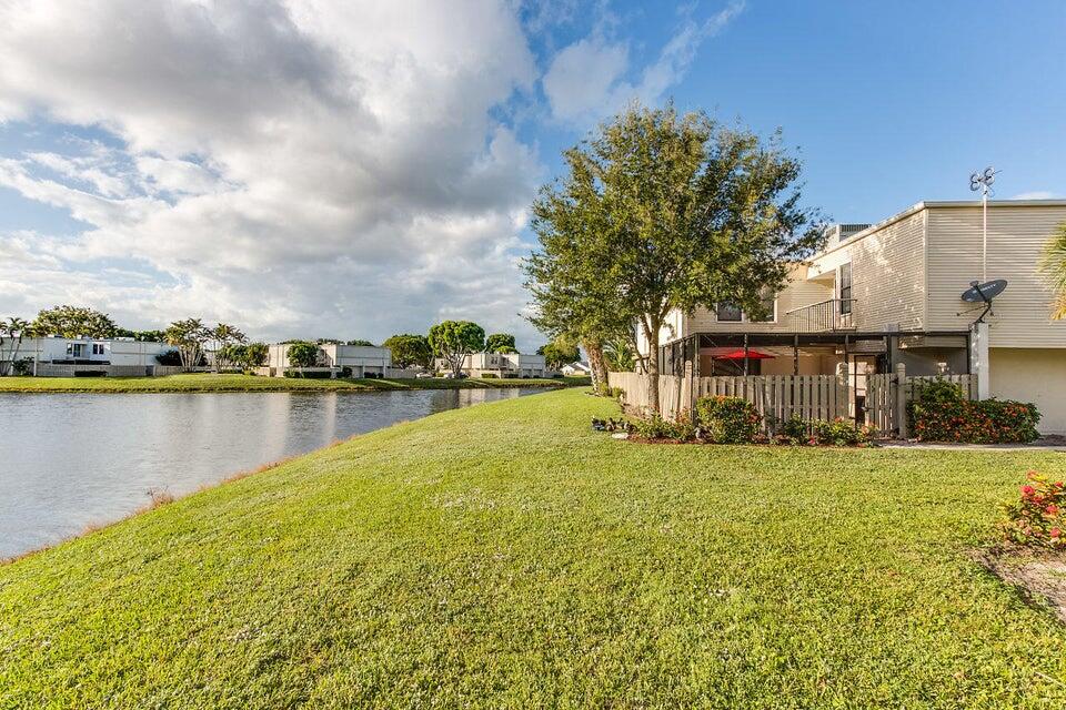 Welcome to this two-story townhome located in the heart of Wellington.  This warm and inviting home has a spacious main level and two masters on the second level.  This residence faces the sunset and canal with a warm and relaxing atmosphere.  Enjoy the private patio area or upstairs balcony while watching the sunset.  This delightful townhome offers an unbeatable location close to world class equestrian events, shopping, dining and top rated schools.  Experience the best of Wellington in this warm and inviting home perfect for seasonal visitors, equestrian enthusiasts or year round living.  New roof was installed 2025.