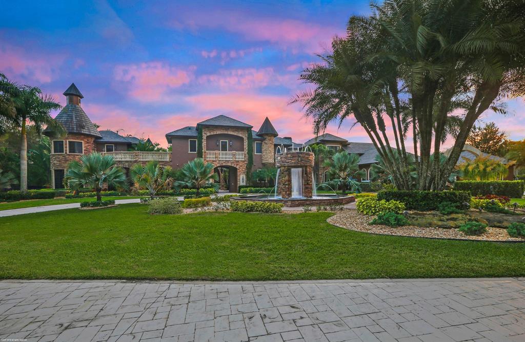 Distinguished by spectacular exterior and interior architectural elements this prestigious estate built by Terry Shore, is situated on a fully fenced and gated 7+ acres with 22,000 sq. ft. of total living space. Luxury and sophistication define this strikingly elegant residence with 12,000 sq. ft. in the main house and 1,200 sq. ft. in the guest house with full kitchen, a separate 2-story exercise room with separate sauna and steam bath can also be used as guest quarters. The estate also features a 9-car, climate controlled garage, a 10 person movie theater, an English Pub room with billiards, 3 fireplaces and a floor to ceiling fully built-in office with wainscoting, all impact windows and doors and a full house generator. Hand painted groin ceilings, three laundry rooms and Crestron lighting and home automation system. This lushly landscaped property features a dramatic resort style 80,000 gallon, heated salt water million dollar pool and spa, custom built by AAA Pools, a lighted tennis court, a putting green/Par 3, and 2 exterior fountains and a wishing well.... bring your horses ......300 yards to the equestrian center"
