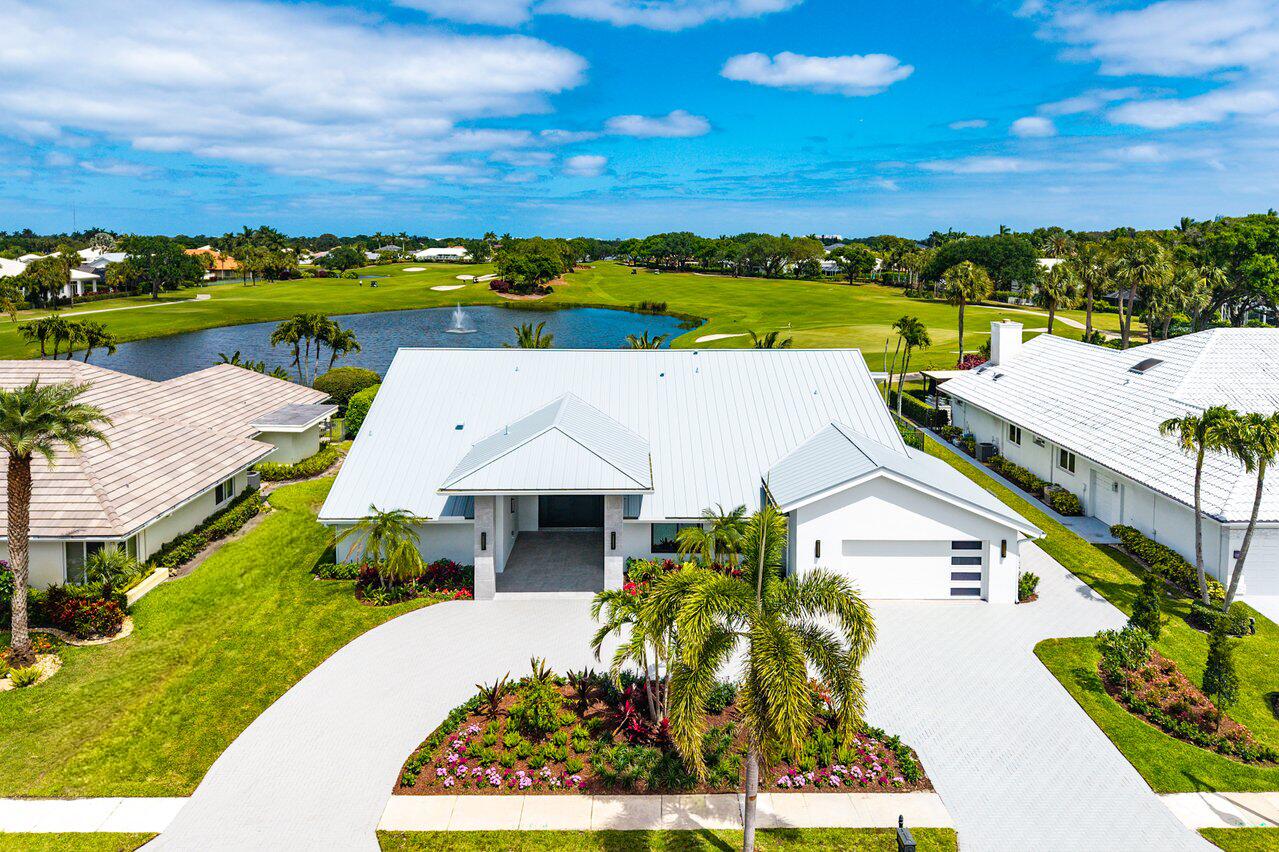 This is truly a fabulous, one-of-a-kind residence, masterfully reimagined and rebuilt to stand as one of the most spectacular homes in Bocaire Country Club. Perfectly positioned on one of the community's most coveted lots, this home offers an unparalleled blend of sophistication, comfort, and resort-style living. From the moment you arrive, the home makes an unforgettable impression. A newly redesigned contemporary front elevation creates a dramatic architectural statement, complemented by a lush, tropical circular driveway that sets the tone for what awaits inside. Ideally located within walking distance to the clubhouse, the home offers both convenience and prestige. Step through the doors and you are immediately greeted by soaring ceilings, walls of windows, and expansive glass  sliders that flood the home with natural light. The result is an exceptionally bright, airy interior, enhanced by breathtaking panoramic views of the golf course and tranquil lake beyond. The seamless indoor-outdoor flow is truly extraordinary, creating a living experience that feels both open and connected to the surrounding landscape. Designed for both grand entertaining and everyday enjoyment, the home features an expansive outdoor living area with a resort-style pool and oversized patio, framed by sweeping views and accessed effortlessly through the home's extensive sliding glass doors. This is indoor-outdoor living at its finest—ideal for hosting or simply enjoying the serene setting. At the heart of the home is a magnificent chef's kitchen, anchored by an oversized island and surrounded by walls of glass that continue to bring in natural light and stunning views. A spacious breakfast area or den offers additional flexibility. Outfitted with top-of-the-line Thermador appliances, a walk-in pantry, and an abundance of custom cabinetry, this space is as functional as it is beautiful. Elegant porcelain tile flooring flows throughout, reflecting light and enhancing the home's modern, luminous aesthetic. The residence offers four graciously proportioned bedrooms, each thoughtfully designed with comfort and scale in mind. The primary suite is truly exceptional, featuring expansive windows that overlook the pool and lake, filling the space with natural light. A private sitting area provides the perfect setting for a library, fitness space, or quiet retreat. The spa-inspired primary bath is nothing short of extraordinary, showcasing a freestanding floating tub, dual vanities, a two-entry walk-in shower, and dual commodes, all finished with exquisite custom tilework and millwork. With four and a half beautifully appointed bathrooms, every detail throughout the home has been carefully curated to reflect both luxury and functionality. Additional features include a durable metal roof and a full-house generator, ensuring comfort, security, and peace of mind year-round.  This is more than a home—it is a statement property, defined by light, space, and design, perfectly suited for those who appreciate elevated living and effortless entertaining.  Bocaire Country Club is a prestigious boutique mandatory membership community of just 239 homes offering a newly renovated clubhouse, championship golf course, tennis, pickleball, 24-hour fitness center, exceptional dining, and vibrant social programming for parents, children, and grandchildren alike. Ideally located among the easternmost country clubs, Bocaire is minutes to beaches, shopping, and dining, perfectly positioned between Mizner Park and Delray Beach's Atlantic Avenue. Zoned for A-rated public schools including Calusa, Omni, and Spanish River, with excellent private school options nearby. This is more than a renovation. It is a fully fortified, technologically advanced, resort-inspired estate delivering luxury, security, and modern sophistication at the highest level.
