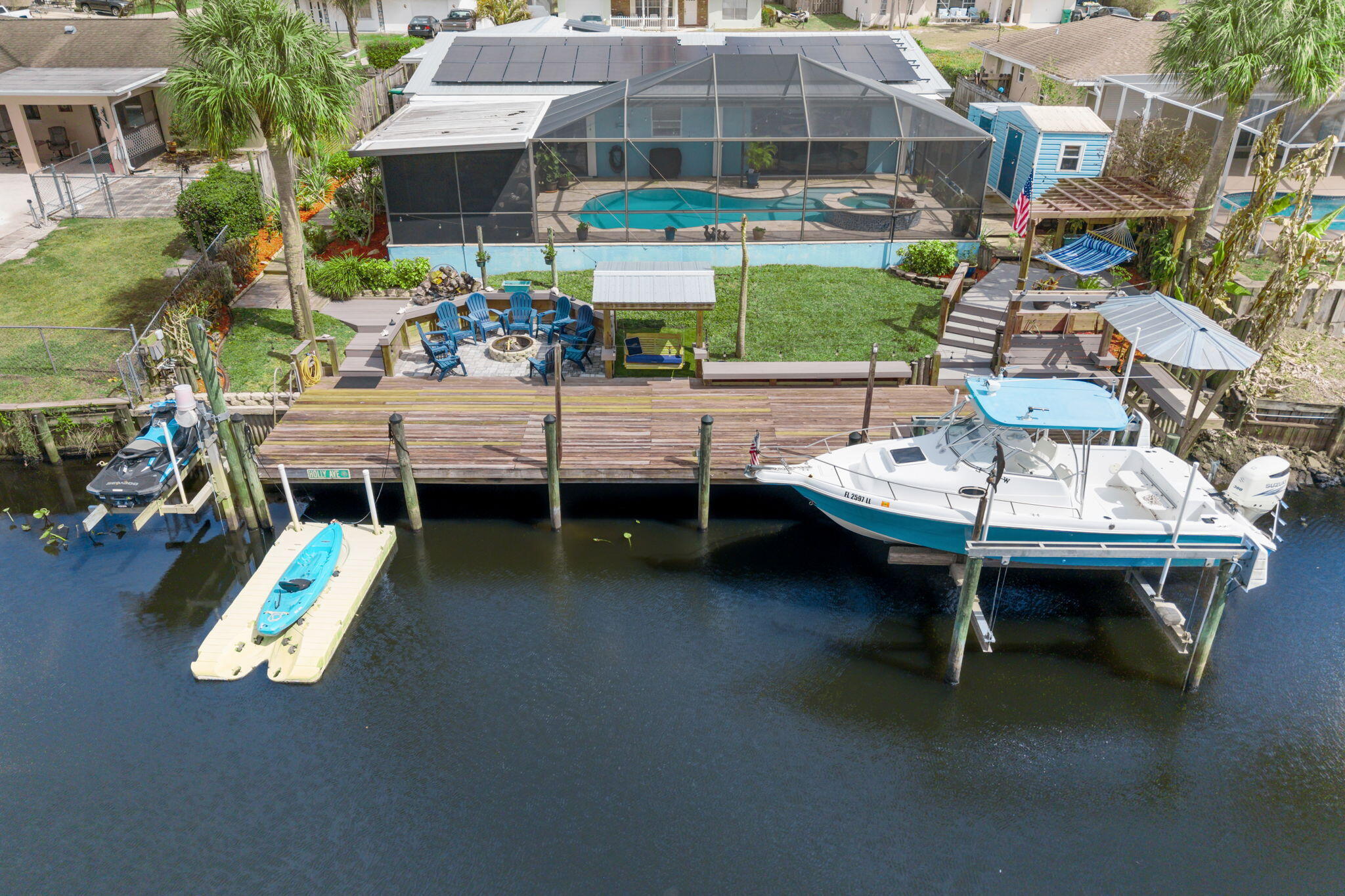 Affordable waterfront living on the St. Lucie River with OCEAN ACCESS, panoramic preserve views, and lower ownership costs. This private retreat features a dock with dual lifts for boat and jet ski, floating kayak dock, saltwater pool/spa, and spacious outdoor living perfect for entertaining. Bright open interiors flow seamlessly outside through pocket sliders off the living room and primary suite. Air-conditioned flex space offers potential for a 3rd bedroom, office, or gym. Major savings come with a 2021 roof, fully paid solar panels (offering consistent minimal electric bills), and county-only taxes. RV hookup/storage plus easy access to dining, shopping, and boat launches complete this value-packed outdoor living Florida lifestyle!