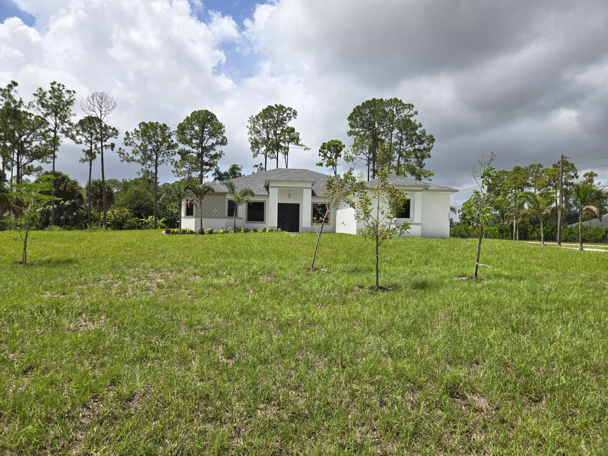 Brand-new construction in the heart of Loxahatchee! This beautifully designed 5-bedroom, 3-bathroom home sits on a large corner lot on a paved main road with NO HOA. Offering 2,714 sq. ft. under air and 3,790 total sq. ft., the home features an open, functional floor plan, modern finishes, spacious living areas, and abundant natural light. The expansive property offers room for boats, RVs, toys, animals, or future additions. Conveniently located near major roads, shopping, dining, and top-rated schools while still offering the privacy and lifestyle Loxahatchee is known for. Information provided by builder and must be verified by buyer. Welcome to this stunning brand-new construction home in the heart of Loxahatchee! Situated on a large corner lot along a paved main road, this beautifully designed 5-bedroom, 3-bathroom residence offers the perfect combination of modern luxury, space, and freedom — all with NO HOA. Boasting 2,714 square feet under air and 3,790 total square feet, this spacious home features an open and functional floor plan ideal for both everyday living and entertaining. Enjoy high-end finishes, generous living spaces, and abundant natural light throughout. The expansive property provides endless possibilities with room for boats, RVs, toys, animals, or future additions. Conveniently located with easy access to major roads, shopping, dining, and top-rated schools while still offering the privacy and lifestyle Loxahatchee is known for. Don't miss this opportunity to own a brand-new home on a premium corner lot with no restrictions in one of Palm Beach County's fastest-growing areas.