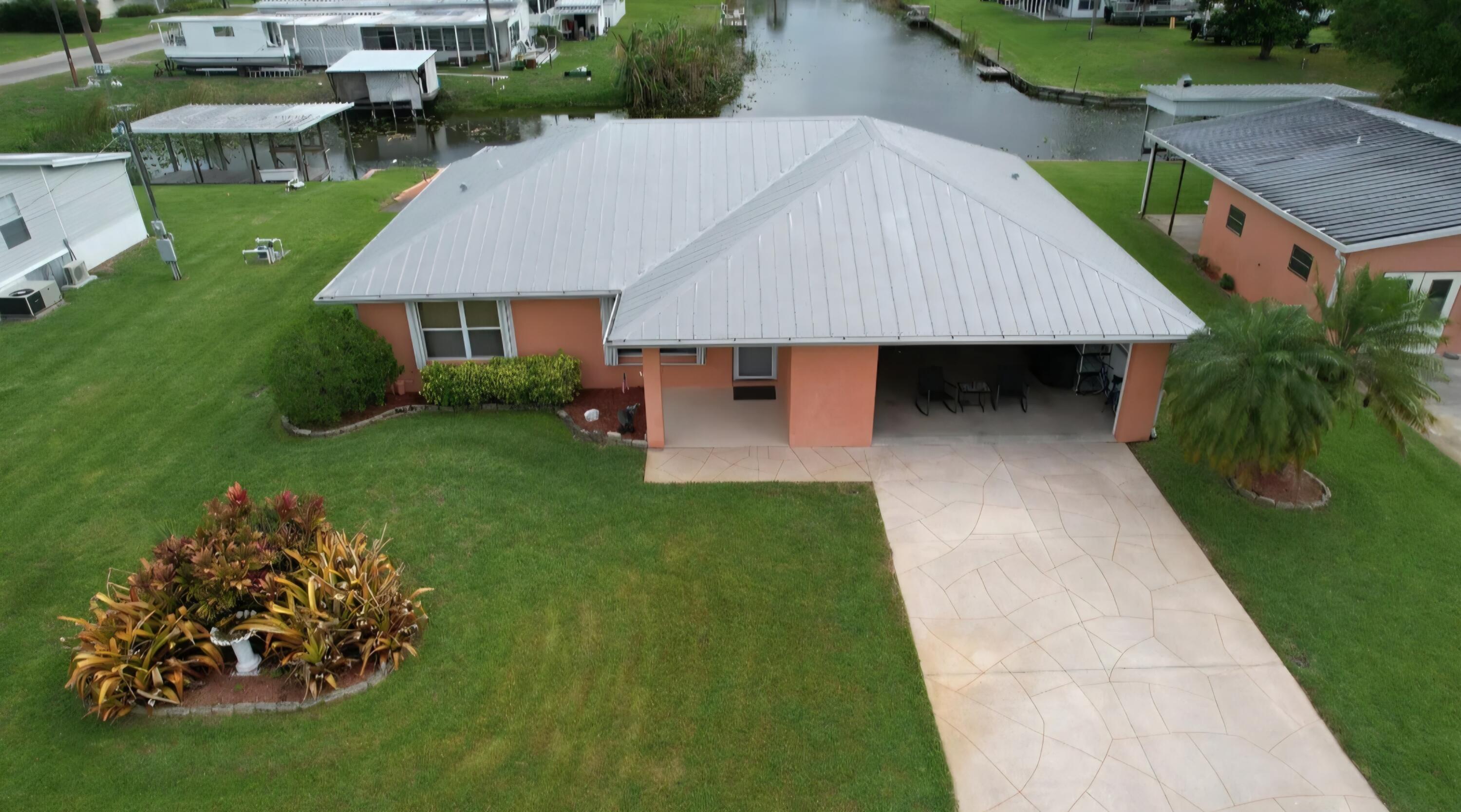 Furnished 3/2/2 with Lake Okeechobee access. This beautiful home on nearly half-acre, features tiled floors throughout, a 2-car garage, metal roof, accordion shutters, kitchen skylight, kitchen island, new fridge & dishwasher, a large screened rear porch, an additional detached enclosed garage/storage building that has a separate half bath. The double driveway features a shuffleboard court and full RV hookups & generator hookup. Waterfront features include a covered boat house w/electric lift, boat dock, boat ramp and a large oak shade tree. Irrigation uses canal water and covers the expansive yard. Located in Buckhead Ridge, a friendly "smile & wave hello" community. Public road recently paved. No HOA. No flood zone. Schedule a showing today!