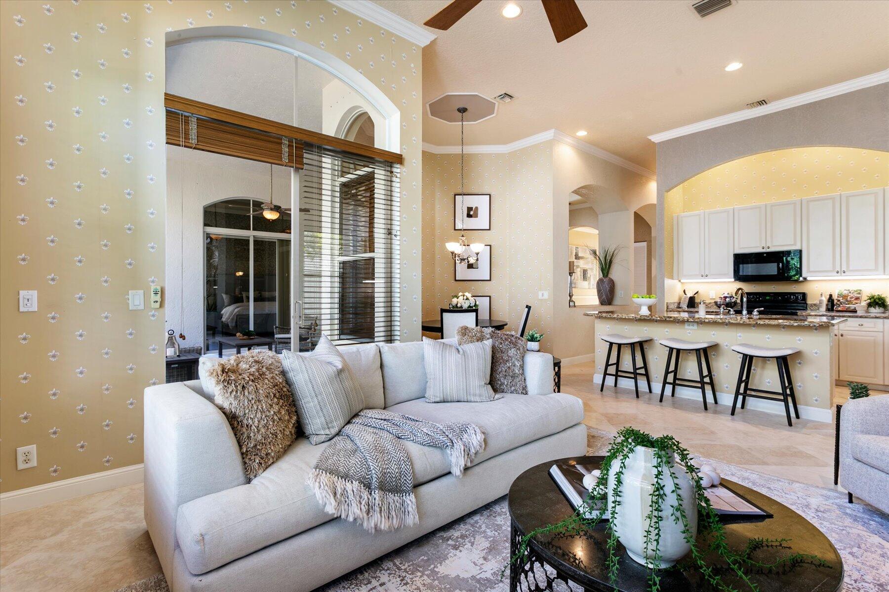 Welcome to a refined yet comfortable lifestyle in the highly desirable Grande Estates section of Journey's End.  Ideally positioned on a corner lot, this single-story residence offers 4 bedrooms, 3 bathrooms, and an effortless layout designed for both everyday living and elegant entertainment.  Step inside to soaring 12' ceilings, Saturnia marble flooring, crown moldings, and an abundance of natural light that fills the home with warmth and sophistication. Formal living and dining areas create an inviting first impression, while the open-concept kitchen featuring granite countertops, 42" Cabinets, a center island with bar seating, and a sunlit breakfast nook flows seamlessly into the spacious family room, making it the true heart of the home.   Privately tucked away, the primary suite offers a tranquil retreat with a coffered ceiling, dual walk-in closets, plantation shutters, and a spa-inspired bath complete with soaking tub, separate shower, and dual vanities. A versatile office or secondary bedroom within this wing, with French doors and its own full bath, is ideal for guests, a home office, or multigenerational living. The split-bedroom floor plan provides two additional bedrooms with walk-in closets and a shared full bath, offering both comfort and privacy. Enjoy true indoor-outdoor living from the expansive screened patio, accessible from the main living areas and the primary suite. Open patio overlooking garden and a slice of tranquil lake views, this space extends your living area and is ideal for relaxing or entertaining year-round. Additional highlights include laundry room with full-size washer and dryer, phantom screens, beautifully manicured landscaping, freshly painted exterior, accordion shutters, 2016 A/C, 2024 water heater, and roof 2002.  Journey's End is a beautifully maintained, guard-gated community known for its resort-style amenities, including a clubhouse, pool, fitness center, playground, tennis, pickleball, and basketball courts. Ideally located near top-rated schools, shopping, dining, and major highways, this home offers both convenience and lifestyle. This is an exceptional opportunity to own in one of Lake Worth's most sought-after communities.