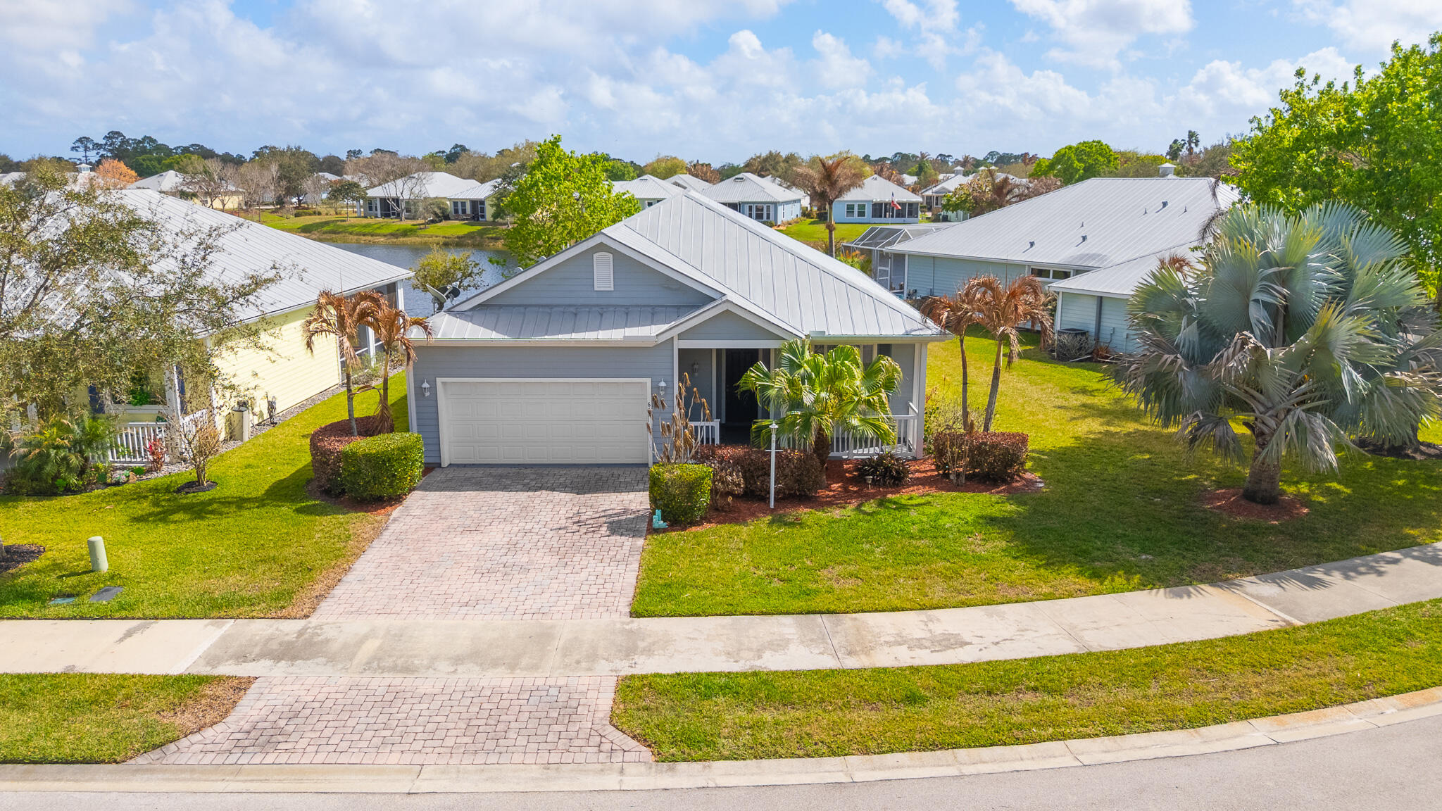 Welcome To This Charming Key West-Style Lakefront CBS Home, Where Timeless Design Meets Modern Updates. Situated In the Highly Desirable River Place Community in Port St. Lucie, This Residence Offers Both Comfort and Convenience in a Serene Setting. Inside, The Spacious Open-Concept Kitchen Flows Seamlessly into The Living Room, Ensuring You Stay Connected While Entertaining or Spending Time with Family. Also Included in This 1499 Sq Ft Home, You Will Find an Open Concept, Great Living Room as You Enter the Home from the Front Entryway. The Back Wrap-Around screened Porch with Plank Wood Ceilings Provides a Peaceful Spot to Enjoy Lake Views and Fresh Breezes Year-Round. The Flexible Third Bedroom, Enhanced by Glass French Doors, Can Serve as a Guest Room, Home Office, or Creative Space. The Primary Suite Retreat Features Sliding Glass Doors That Open Directly to the Screened Porch, Framing Tranquil Water Views. Durable Tile Flooring Throughout Adds to the Home's Low-Maintenance Appeal.  Features Include a Durable Metal Roof, 2024 A/C Fan Motor, 2024 Washer & Dryer, Hurricane Panels for Storm Protection, Irrigation System, and Surge Protector, Paver Driveway for Added Curb Appeal, and Classic Fiber-Cement Siding. River Place is Celebrated for Its Beautifully Maintained Green Spaces and Resort-Style Amenities, Including a Clubhouse with Pool and Private Boat Ramp to the Scenic St. Lucie River, Basketball, Baseball, Soccer Fields, and a Children's Playground. Low HOA Fees Cover Lawn Care (Including Front/ Back/ Side Lawn, Tree/ Shrub Trimming, Edging of Driveway/ Sidewalk Area, Lawn Fertilizer, and Lawn Pest Control). Community Pool Service, and All Common Areas. Enjoy The Perfect Balance of Privacy and Accessibility. Just 5 Minutes to Publix, Shopping Centers, and a Wide Variety of Local Dining Options. This Home is More Than Just a Place to Live, It's a Lifestyle.