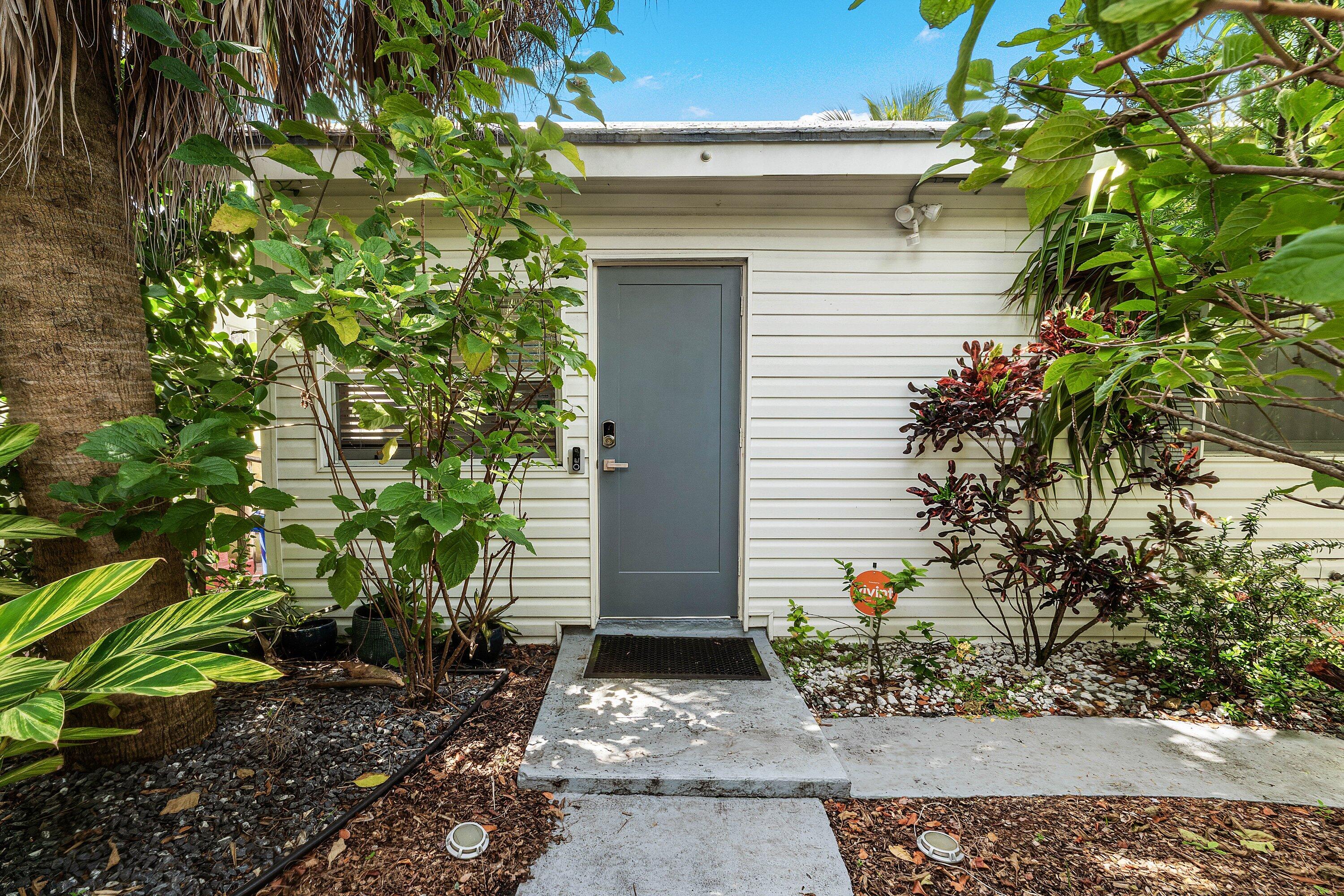 This Secret Cottage is both elegantly stylish and warm-welcoming at the same time. Located smack dab in the middle of downtown Lake Worth Beach artisan district yet you are transported to a calming Zen when you enter the property. There is a complete privacy hedge and a multitude of cooling shady landscaping in the front and back yards. Inside, the foyer currently is set as a small office.  Proceed to the living area which is roomy and bright. The kitchen has lovely granite countertops. Bedrooms are split and private.  Laundry inside. This conveniently located property would make a great primary or vacation home, and with MU-E—MIXED USE EAST zoning you have live/work, or potential office/business use options.