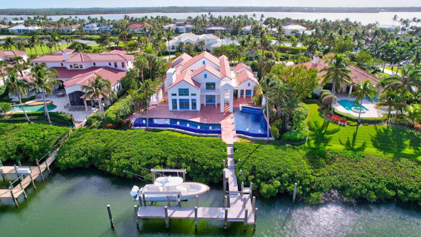At the intersection of architecture, nature, and water lies this unparalleled estate in the exclusive community of Sailfish Point. Every detail has been meticulously crafted from the dramatic architecture to the resort-style mosaic pool spanning the width of the property. Plenty of natural light flows throughout the home with walls of glass and internal courtyards designed to offer private spaces. The chef's style kitchen has Thermador appliances, 2 islands, a breakfast area, and connects to the dining room via a butler's pantry. The expansive great room opens to the bar/lounge area perfect for entertaining. The primary suite offers a spa-like bath with steam shower and soaking tub. A protected dock, with a 24,000# lift, provides immediate access to the Indian River and Atlantic Ocean. Sailfish Point offers the ultimate Florida resort-like lifestyle with its oceanfront country club, fine & casual dining, HydroGrid tennis courts, Jack Nicklaus 'Signature' golf course, state-of-the-art fitness center & spa, helipad, 1.5 miles of gorgeous beach, full-service marina & the ultimate in private security. Sailfish Point is also located within minutes of Witham Field, suitable for landing large private aircraft with US Customs on-site.