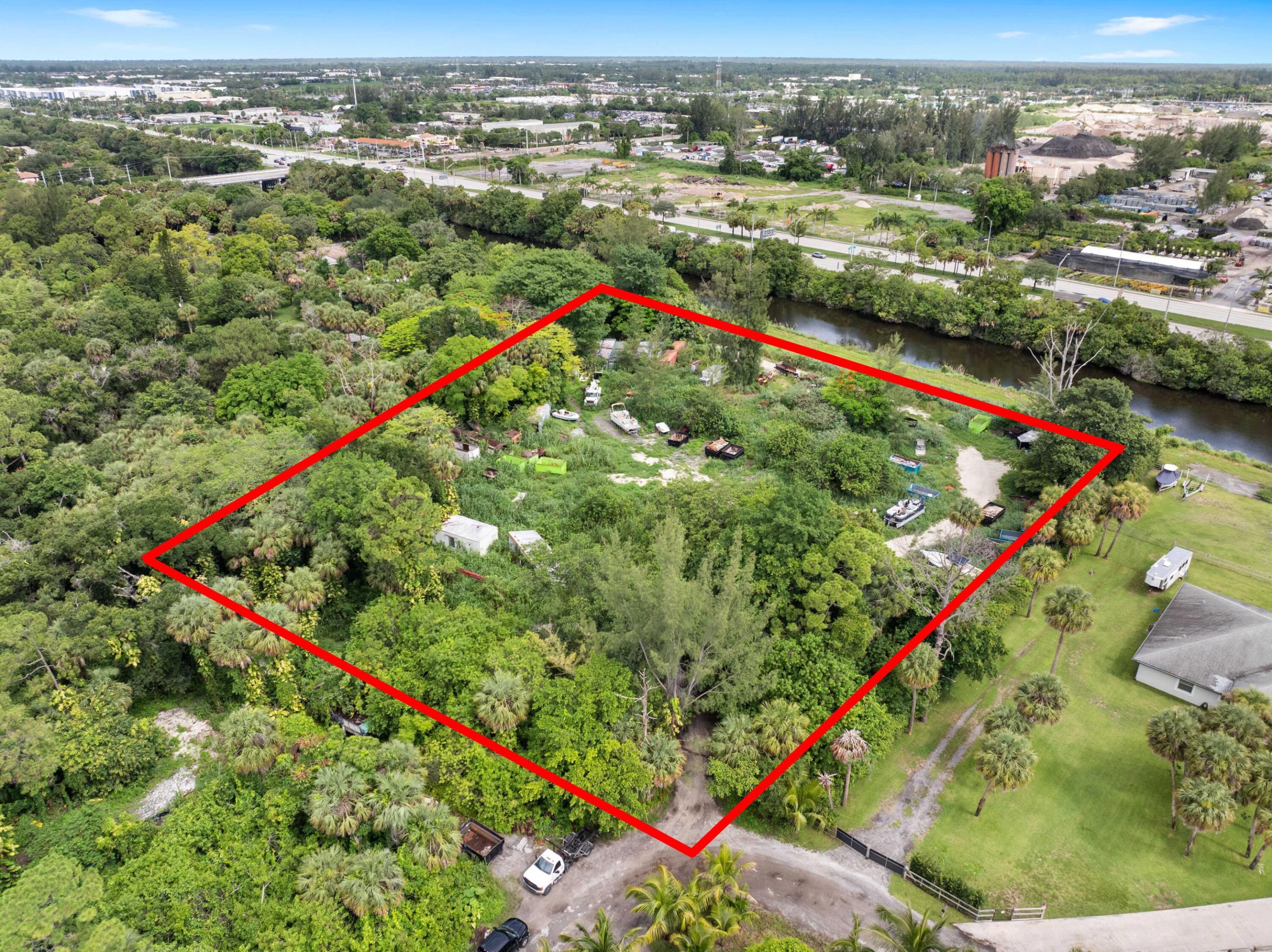 Vacant land. Incredible 5.04-acre waterfront property featuring approx. 3.04 acres of upland and a 2.00-acre private road easement. Fully fenced and gated, with 600 feet of water frontage on the C-51 Canal, a navigable waterway maintained by the U.S. Army Corps of Engineers. Riparian rights included, allowing the opportunity to build a private dock and keep your boat in your backyard. The deeded 60-ft private road offers rare privacy and control. Ideal for adding a gated entrance. No HOA. Located near Southern Blvd and the Turnpike, just 15 mins to PBI Airport. Sail to Lake Osborne. A truly one-of-a-kind, build-ready site in a rapidly developing area. Survey can be found under ''documents''.