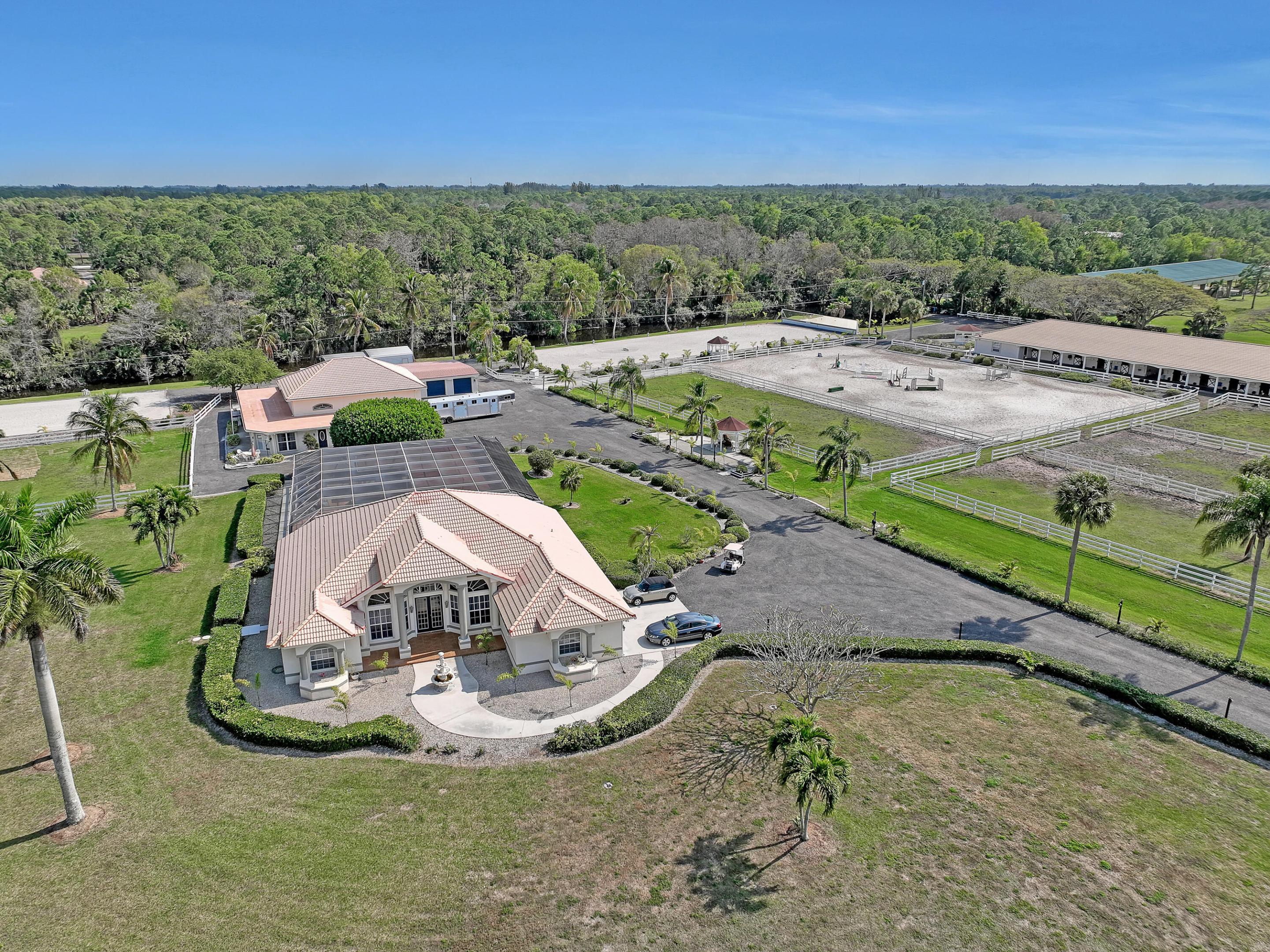 Custom Equestrian property in sought after White Fences community. situated on 10 acres 2 parcels 3426 & 3406 with 31 12x12 horses stalls, 2 mirrored arenas, 6 paddocks suitable for dressage, show jumping or 3 day eventing. . Main house has 5 bedrooms / 3 bathrooms with an open kitchen,formal dining room,den, living room and large game room. Inground  pool & spa in screened patio area with outside kitchen. Guest house has 3 bedrooms/ 3 bathrooms with an eat in kitchen. living room and screened patio area. There are also 4 separate 1 bedroom 1 bath apartments on the property. Separate 3 car garage and 1 RV garage with lots of storage space. Separate gate entry to the barns for staff. Hurricane shutters as well. Zoned agriculture. 2 seperate parcels on property. Great Investment property