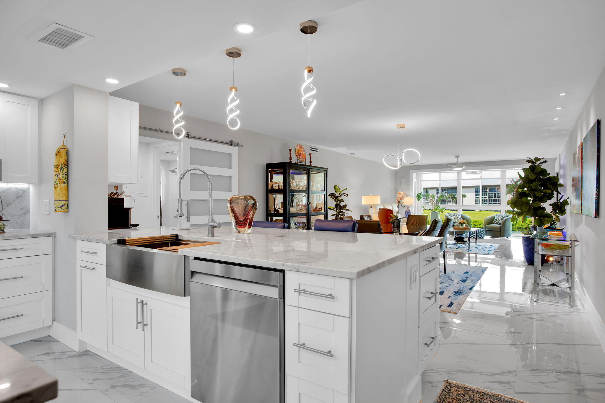This beautifully upgraded Corner Luxury Floor plan residence features all-impact windows, a secure front entry door, and an enclosed patio that opens seamlessly to the living room. Modern conveniences include keyless entry, a Nest thermostat, stylish porcelain flooring throughout, and "smart" Samsung kitchen appliances that can be controlled via smartphone. The chef-inspired kitchen boasts quartz countertops, an oversized sink, a spice drawer, a pull-out waste-and-recycling drawer, a built-in wine refrigerator, and a Samsung refrigerator with a water and ice dispenser and an integrated smart screen. The oven offers multiple cooking functions, including bake, broil, convection bake, roast, air fry, dehydrate, and bread proofing.   Every room, including the primary bathroom, is equipped with remote-controlled ceiling fans, while the living room features power shades. The bathrooms are fitted with touch-light vanity mirrors and easy-access vanity drawers. The primary suite includes an enlarged closet, and the primary bathroom showcases an oversized shower with a rain showerhead. All work is done by the architect with Permits. THIS CONDO IS A 'WORK OF ART".