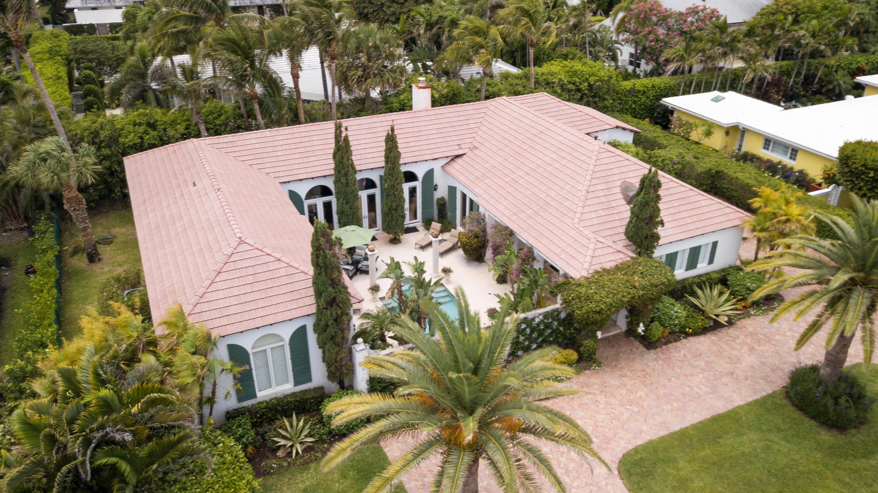This unique Palm Beach Courtyard home sits on a quiet residential island enclave on the desirable Palm Beach's Southend and boasts 3,146 square feet of interior living space with 3 bedrooms, 3 full baths, 2 car garage and old brick circular drive. Designed by Ballinger Award winning architect, Raphael Saladrigas, the interior features an expansive great room with lofty tray ceilings, beautiful marble floors with Verde S. Denis marble accents in the foyer and fireplace surround. The mantel piece is from the late 1800's. The master en-suite has double walk-in closets and marble appointed bathroom with double sinks. Both the master en-suite and the great room, open to the private courtyard, a tranquil outdoor living area featuring a fountain, heated saltwater pool and a relaxing tropical setting.
This property is ideally located within walking distance to Phipps Ocean Park Beach and Raymond Floyd Golf Course.