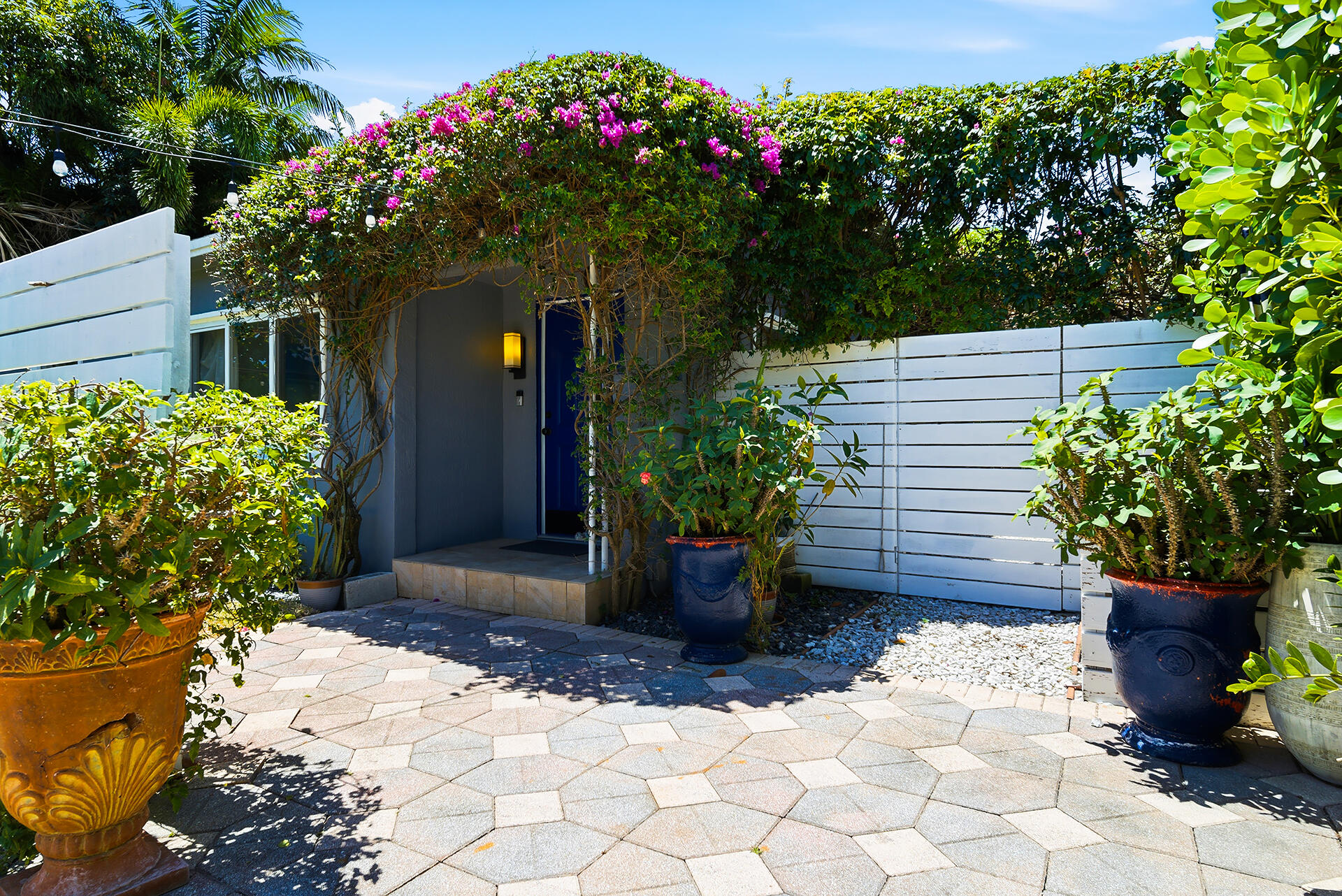 Welcome to this charming 4 bedroom, 2-bathroom home conveniently located just east of 95 on a quiet street with a private fenced in yard, great for activities and entertaining!   Arched bougainvillea vines greet you upon arrival, while lush grass and string lights flow from the front to the back yard. Vertical gardens and a large, shaded patio create a relaxing retreat outdoors.   Concrete block construction and impact windows offer peace of mind, while updates such as fresh white paint, tile floors and stainless-steel appliances give an updated aesthetic to your interior space. This home is available for annual lease.   No pets. No smoking.