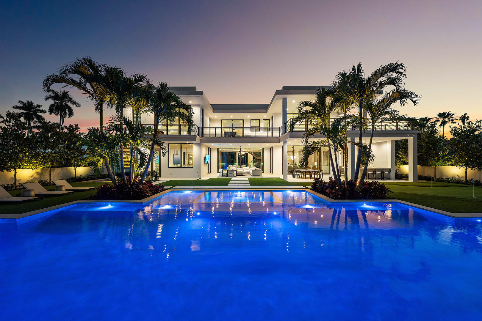 Discover a newly completed signature estate by SRD Building Corp., exquisitely designed by award-winning P&H Interiors, set within the prestigious Royal Palm Yacht & Country Club on an oversized interior lot. This exceptional residence blends architectural precision with curated luxury, offering an elevated lifestyle defined by thoughtful detail and refined craftsmanship. A striking entry reveals an expansive, open layout anchored by a state-of-the-art chef's kitchen with eat-in dining—ideal for both intimate gatherings and elegant entertaining. The sleek clubroom is designed for effortless hosting, featuring a full bar, billiards area, and a glass-enclosed wine room. A private library provides a quiet retreat, while the dramatic show garage--framed by a glass wall--adds a bold architectural statement. The home overlooks the 16th green, creating a picturesque backdrop of manicured fairways and year-round greenery.  Outdoors, a 72-foot lap pool spans the backyard, complemented by a spa, a putting green, and a manicured turf lawn. The covered terrace, complete with a summer kitchen, creates a seamless indoor-outdoor living experience ideal for year-round enjoyment.  The second floor features dual primary suites, each with a private balcony offering serene views over the grounds. Crestron smart-home technology provides intuitive control of lighting, climate, and security throughout. Additional highlights include an elevator, full-house generator, natural gas service, and refined designer finishes throughout.  Buyer is responsible for documentary stamp taxes on the deed and title insurance.