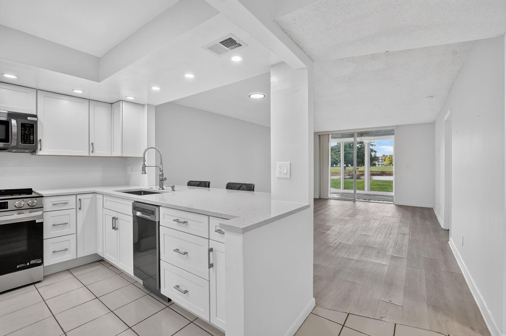 Beautifully renovated ground-floor condo in Palm Springs 2, a sought-after 55+ community in Margate. The fully updated kitchen features white shaker cabinets, quartz counters, and stainless steel appliances, opening to a bright living area with wood-look flooring. One bedrooms, two  baths, and in-unit laundry add everyday comfort, while the primary suite offers its own private en-suite bath. A standout enclosed Florida room with wall glass doors offers peaceful lake views, perfect for morning coffee. Residents enjoy heated pools, a fitness center, sauna, clubhouse, library, billiards, and shuffleboard, all set on a public golf course with no membership fees. Minutes from Coconut Creek and Coral Springs. Move-in ready!