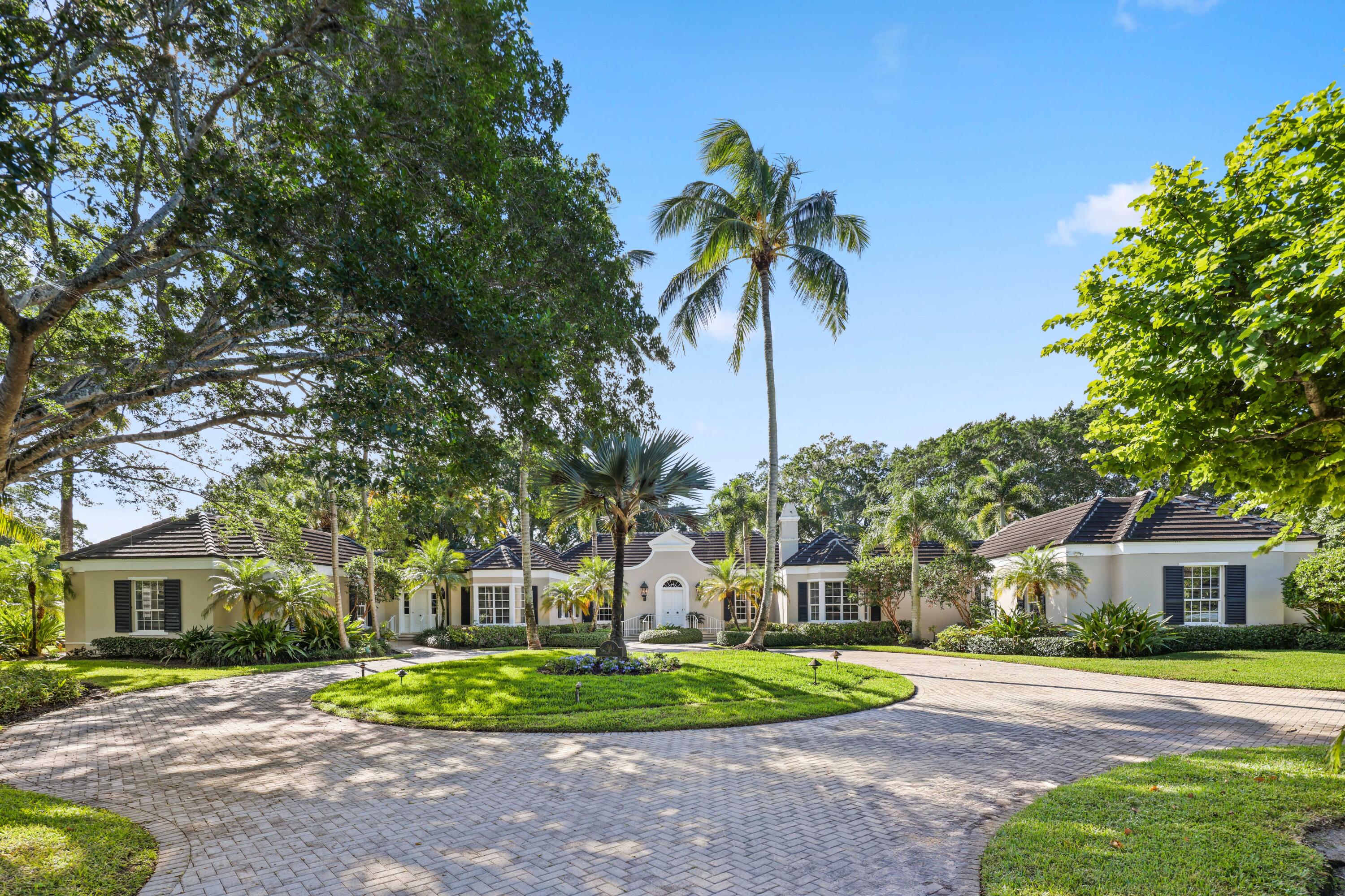 Discover unparalleled elegance and timeless charm in this stunning 6-bedroom, 6.1 bath estate nestled on 1.82 acres in the prestigious Village of Golf. Offering 6,761 total square feet and 5,665 living square feet, this meticulously maintained home seamlessly blends classic sophistication with updated amenities. Elegant steps lead to the stately front door, opening into a gracious foyer that flows seamlessly into the grand living and great room. Here, soaring tray ceilings, refined archways, and an expansive wall of sliding glass doors create a sophisticated backdrop, unveiling a picturesque patio and pergola with landscaped privacy and tranquil golf course views. Designed for elegant entertaining, the formal great room offers distinguished living and dining spaces, while the charming garden room, complete with a wet bar, enhances the home's warm and inviting atmosphere. The eat-in kitchen boasts granite countertops, a spacious pantry, and top-tier appliances and leads to an inviting family room with a cozy fireplace and built-in bookshelves. A stately den with sliding pocket doors offers the ideal private retreat. The expansive primary suite features a charming bay window, an oversized bath, and generous closet space. A thoughtfully designed guest wing includes two guest bedrooms, each with en-suite baths and walk-in closets, while a separate entrance ensures privacy for visitors. Additional highlights include impact glass windows and a generator for peace of mind, wood floors throughout, 5 AC units & 2 hot water heaters for optimal comfort. This exceptional golf course estate presents an extraordinary opportunity to enjoy privacy, elegance, and the ultimate South Florida lifestyle. Schedule your private tour today!