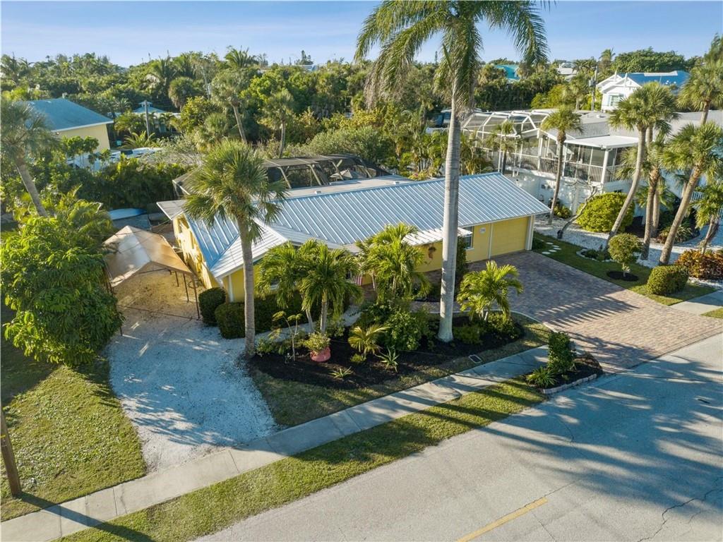 This extraordinary mid century residence located in the most desirable Anna Maria Island stretch of Holmes Beach is surrounded by multi-million dollar homes and offers a short walk to sugar white sand beaches, enchanting turquoise water, restaurants and a separate deeded boat slip with canal access to Bimini Bay and the Gulf of Mexico. This one of a kind residence provides water access and a tropical private back yard with no neighbors behind or overlooking across a canal. The 2,157 square feet of outdoor and indoor living space, oversized screened-in heated pool, outdoor shower, barbecue area, lanai and media center is perfect to relax or entertain. The beautiful entryway is highlighted by a pergola and mature tropical garden, open spacious and bright split floor plan and dual suites. Existing improvements includes new interior and exterior paint, insulated windows, metal roof, front and back pavers, AC duct, impeccable terrazzo floors, immaculate preserved vintage bathrooms, custom kitchen with solid maple cabinetry, granite counters, glass backsplash, top of the line stainless steel appliances, new main suite bathroom with pool access, separate large laundry room, one car garage and ample parking for 4 additional vehicles. This remarkable residence is minutes from Galati's Marina and the Gulf of Mexico. Enjoy majestic sunrise and sunset views, play golf at the Key Royale golf course or cruise to the nearby tropical islands of Egmont Key, Passage Key, and Longboat Key. Take a boat ride for dining at Ocean Star, Swordfish Grill, Tide Tables or Margaritaville, day or night. Schedule your private tour today.