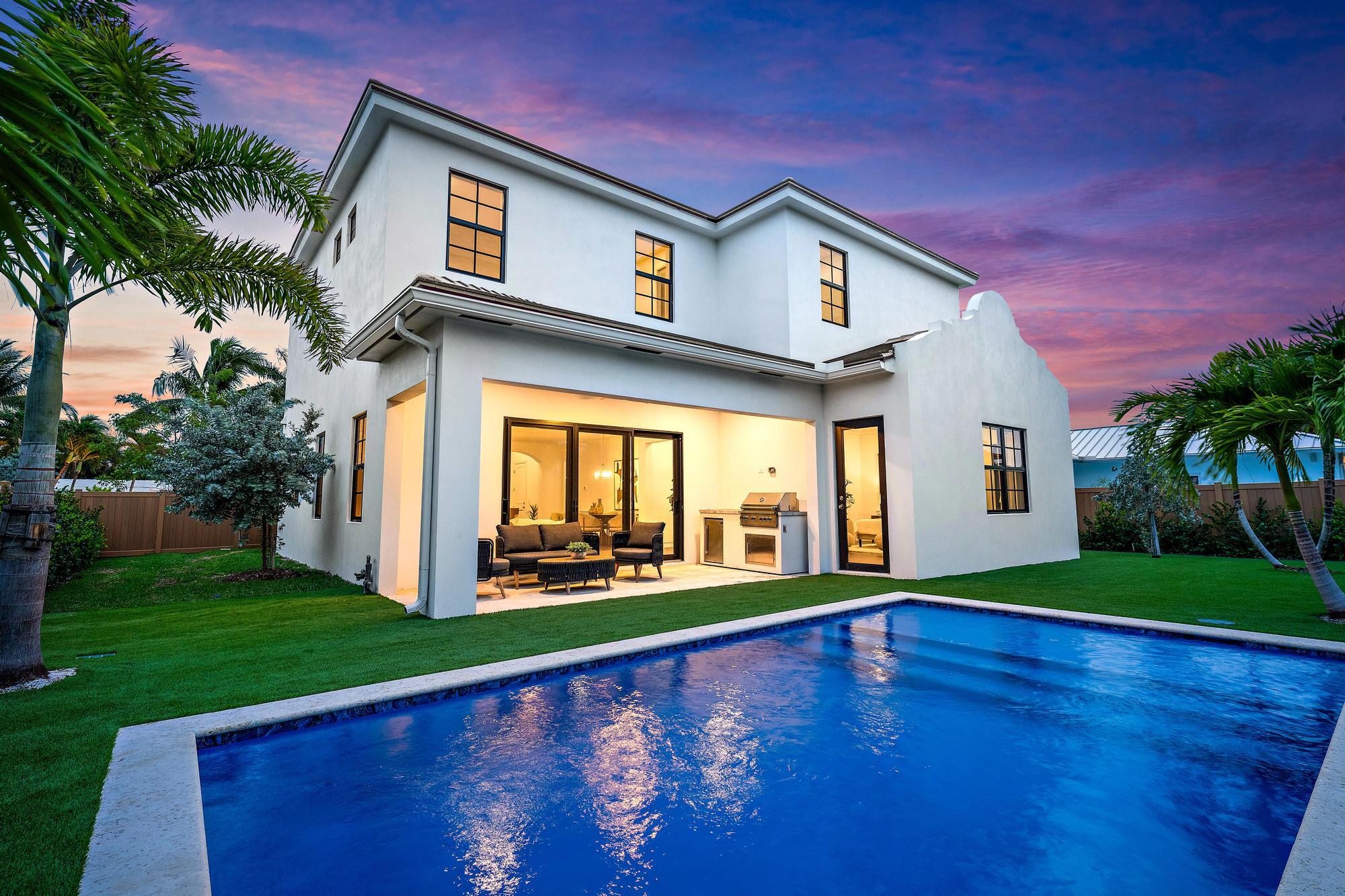 Located in Palm Beach Shores, this never-lived-in new construction home offers a rare opportunity to own a modern coastal residence just minutes from the beach, Palm Beach Inlet, Sailfish Marina, and local waterfront restaurants.  The open floor plan is centered around a spacious kitchen with custom cabinetry, premium appliances, a large island, and seamless flow into the living and dining areas. Large impact glass doors open to the covered patio, creating an easy connection between indoor and outdoor living.  The backyard features a heated pool, summer kitchen, covered lanai, tropical landscaping, and brand-new artificial turf, providing a clean, low-maintenance outdoor space. The primary suite includes a spacious bedroom, walk-in closets, and a well-appointed bath with a freestanding tub and oversized shower. Upstairs, a secondary primary bedroom, two additional guest bedrooms, and a flex room/den offer plenty of space for family and visitors.   Palm Beach Shores is one of the few communities in South Florida where residents can enjoy both the Atlantic Ocean and Palm Beach Inlet just minutes from their front door. With beaches, boating, fishing, dining, and marinas all nearby, this location offers an exceptional coastal lifestyle.