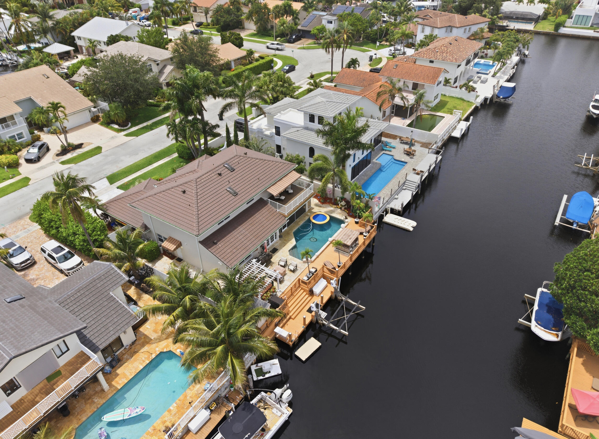 Experience the ultimate Boca Raton waterfront lifestyle in this stunning 5-bedroom, 3.5-bath residence offering 3,429 sq ft of refined living space with direct ocean access. Complete hurricane-impact protection, a new 2025 roof, and 2023 AC provide peace of mind. The thoughtfully designed floor plan features a main-level ensuite bedroom, spacious loft, and a luxurious primary suite with a private balcony overlooking the canal. Outside, enjoy a heated saltwater pool and spa, custom sauna, outdoor kitchen and bar, fire pit lounge, hot tub, screened patio, outdoor shower, artificial turf, and an expansive dock with a 12,000-lb boat lift. Ideally located near Mizner Park, world-class dining, shopping, and Boca's pristine beaches.