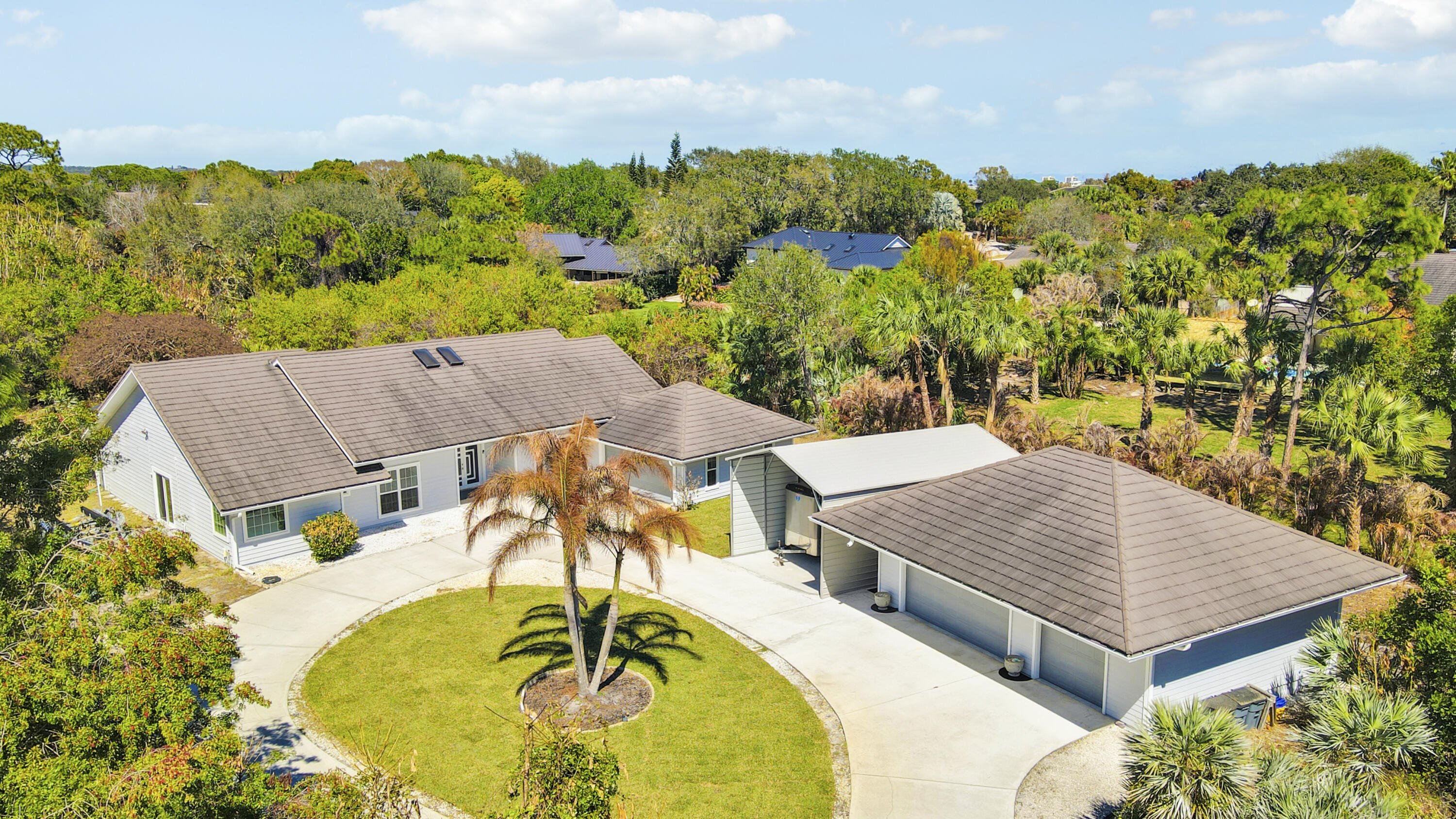 Welcome to your own private compound in Sugarhill,  one of the most sought-after communities in Jensen Beach. Spanning over 2,837 square feet, this beautifully updated home features a spacious new gourmet kitchen with abundant counter space, overlooking a functional open floor plan ideal for everyday living and entertaining. The residence offers three generously sized bedrooms, 2 1/2 updated bathrooms, den and a two-car attached garage + plus an impressive additional three-car air-conditioned building/workshop. Filled with natural light, the home showcases designer accents and tile flooring throughout, creating a bright & cohesive living space. Step outside to enjoy your own private retreat featuring a large patio, sparkling pool with water feature.  Uniquely situated on 1.1 acres.