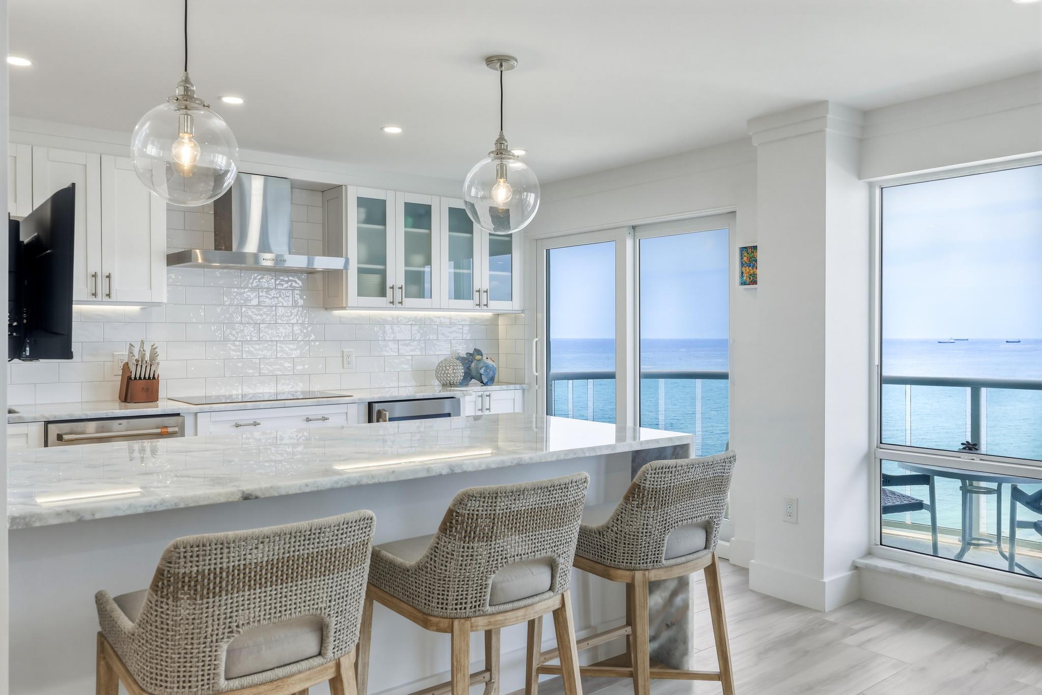 Coastal living at its finest! Beautifully remodeled! This exceptional beachfront residence was thoughtfully redesigned to include a den/office, soundproofing throughout, and a spacious laundry room. Ocean Blue quartzite, coastal-chic porcelain flooring, and a desirable south-facing exposure showcase breathtaking ocean views. The open-concept kitchen features an oversized island with seating, while hurricane-impact windows and sliding glass doors enhance both beauty and peace of mind. The primary suite offers a spa-inspired bath with a rain shower, dual vanities, and a large walk-in closet. Located in Southpoint, a financially secure, resort-style oceanfront community with fully funded reserves, this is a rare opportunity to own a meticulously renovated home directly on the sand.