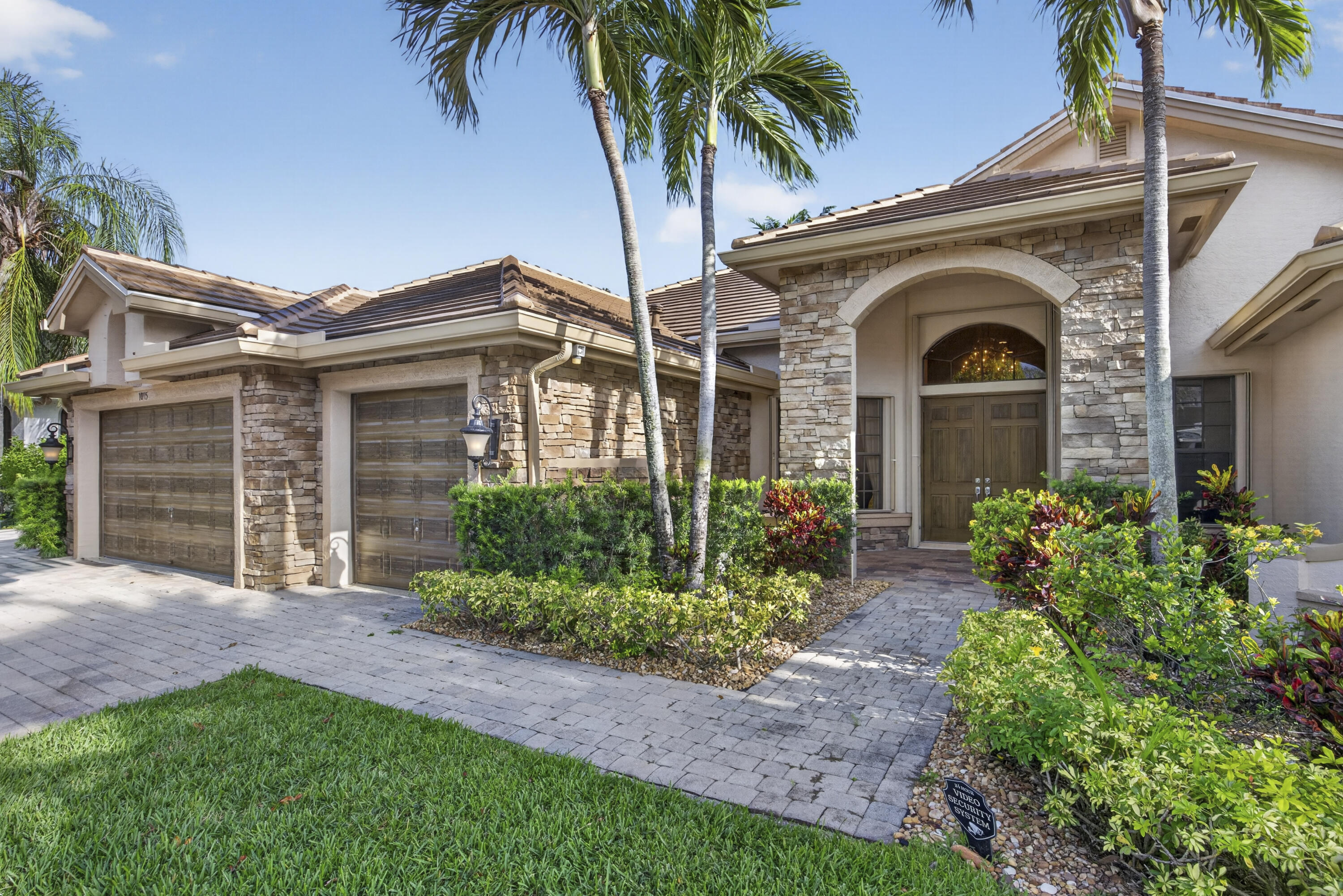 Welcome to luxury living in the prestigious Versailles community of Wellington. This beautifully maintained residence offers a private mother-in-law suite, perfect for multigenerational living. The kitchen boasts a gas stove and outdoor gas hookup for easy grilling and entertaining. Enjoy your private backyard oasis with a sparkling pool overlooking a breathtaking wide lake view. Relax year-round on the covered lanai, featuring electronic roll-down screens for added comfort and protection. Additional upgrades include a cabana bath, outdoor shower, new roof, tankless water heater, and accordion hurricane shutters. The three-car garage and space for up to nine vehicles make this a rare find. Located in a gated community with resort-style amenities and top-rated schools nearby.