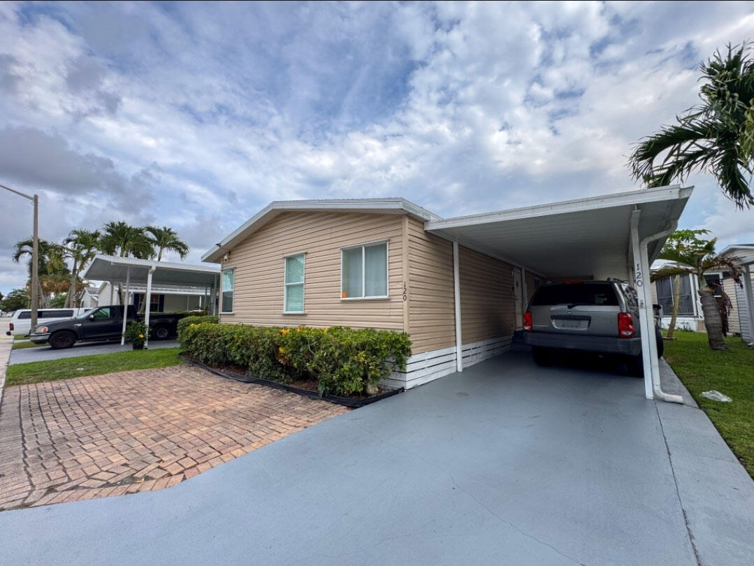 Charming Mobile Home in a community for all ages in Palm Beach Plantation,  Beautiful and comfortable 3 bedrooms and 2 bathrooms, with elegant tray ceilings with wood accents, recessed lighting, with laminate flooring, a private retreat with a wonderful lake view and spacious covered front porch for relaxing, and private carport. All measurements are approximate. This property is available for purchase with Financing or Cash.  Call the listing agent today to schedule your private tour.