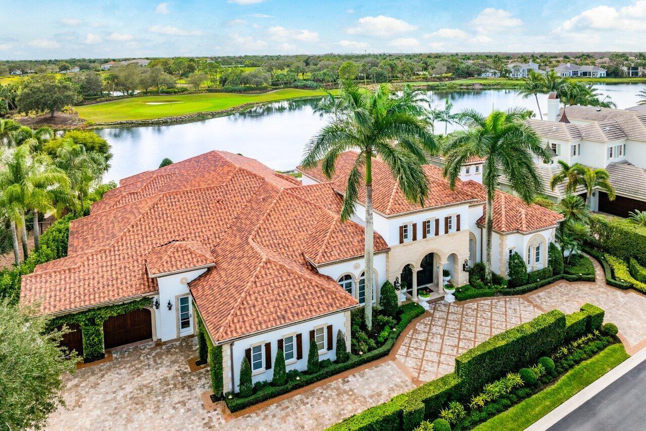 Introducing 108 Via Palacio, a stunning and meticulously maintained estate located in the prestigious Mirasol Country Club community. This impressive home, situated on a spacious 0.46-acre lot offers breathtaking views of water  and the Sunset golf course's 14th hole and features luxurious finishes and upgrades throughout. Boasting 4 bedrooms, 5 full bathrooms, and 2 half bathrooms, this exquisite residence showcases marble, carpet, hardwood, and tile flooring. The gourmet kitchen, renovated in 2023 by Downsview Kitchens, is equipped with top-of-the-line appliances, including a 5-burner induction stove, and a refrigerated wine room with a capacity of approximately 400 bottles. The luxurious primary suite features his and her bathrooms and closets, while the additional bedrooms provide ample space and comfort. A natural gas two-sided fireplace, LED lighting, and Wi-Fi thermostats add to the modern appeal of the home. Enjoy outdoor living at its finest with a beautifully landscaped backyard, offering grass-lined pavers, a beautiful fountain, and a sparkling pool and spa. The summer kitchen, renovated in 2021, and the natural gas pool heater replaced in 2022, make this an ideal space for entertaining. Additional features include a home theater with updated equipment, a whole-house water filtration system, and a whole-house generator powered by natural gas. The property is also equipped with low-voltage LED landscape lighting, impact windows and doors for hurricane protection, and a 3-car garage with space for a golf cart. As part of the Mirasol Country Club community, residents enjoy access to world-class amenities, including two championship golf courses, a state-of-the-art fitness center, spa & salon, 15 har-tru tennis courts, 6 new pickleball courts, children's sports complex and a luxurious clubhouse with four restaurants for a variety of dining options.  The buyers of this home can purchase a highly coveted FULL GOLF membership immediately upon closing or a sports membership if they prefer. Don't miss this opportunity to experience the ultimate in luxury living at 108 Via Palacio. Schedule a private showing today and indulge in the sophistication and grandeur of this extraordinary estate.
