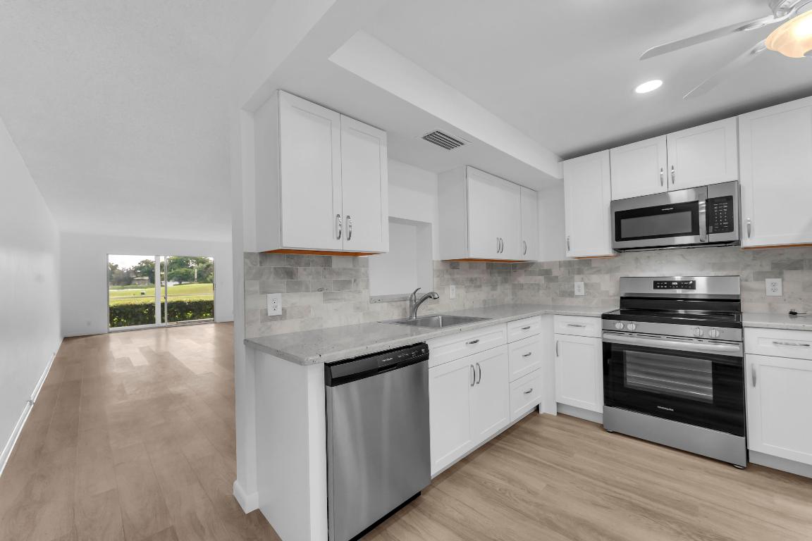Fully renovated unit that is Turnkey, including new vinyl luxury flooring, neutral paint, and LED lighting with ceiling fans throughout. Kitchen features granite countertops and new stainless steel appliances; bath vanities updated. Upgraded A/C for comfort and efficiency. Screened patio with views of the golf course and lake. Roll-up hurricane shutters included. Parking at the door; washer/dryer facility within 20 feet; secure bulk storage lockers. Building recently re-roofed and repainted; solid reserves with no assessments and a recent structural review. Wynmoor offers amazing amenities such as a theater, clubhouse, cafe, pools, fitness, hobby rooms, and easy access to Turnpike/I-95 and the beach, and LOW HOA GREAT INVESTMENT ACT NOW! Call Chase!