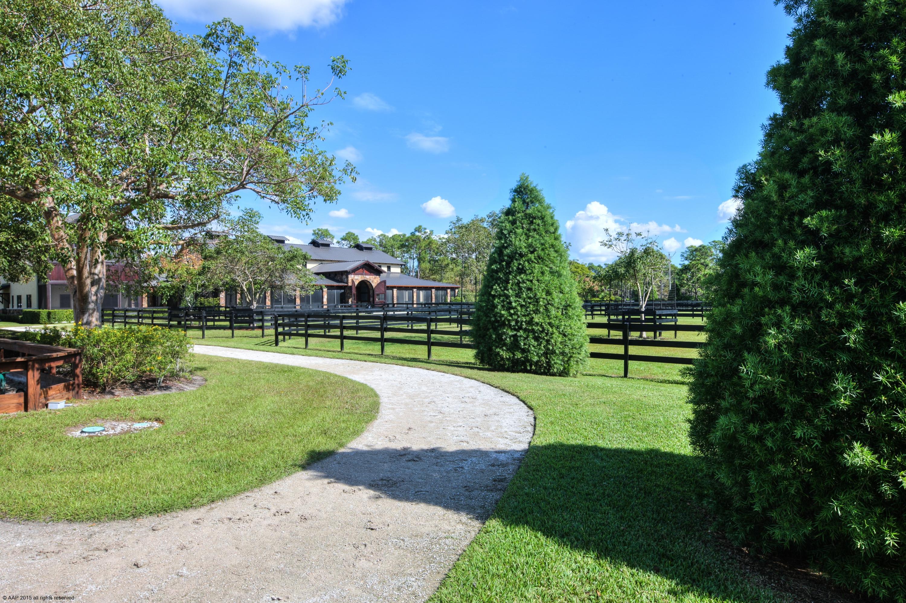 Private 15 acre custom designed home with top equestrian facilities. Unmatched in quality, design & finishes, probably one of the areas finest built properties.  Every detail was meticulously considered.  Stunning stable with exposed wood beam trusses, 3 grooming bays, wash & storage areas. Riding arena with underground watering system, hot walker and round pen.  Beautifully landscaped with private hacking paths throughout which complement the subdivision's trail system. Three grooms apartments and separate ancillary buildings with veterinary / farrier rooms, feed storage and multiple equipment bays.  The main residence features cathedral ceilings, fireplace with floor to ceiling stone chimney, wood & marble floors, elevator, a screened balcony and infinity pool with private water vistas. Sculpture at fountain in barn does not convery.

Property information:

Lawn maintenance: $3,500 (includes mowing, tree trimming, flowers, fertilizer & sprinkler system maintenance).

HOA Dues: $1050 Per lot = $3,150 Quarterly

FPL (electric) Annual Average: $975/mo. House & Barn & Apts $750/mo.

Generator maintenance: $105/Mo.

Pool & Koi Pond: $295/Mo.

Square footage:
Main House: 6,226 Air conditioned living space
Attached Garage: 1,090 Sq. Ft.
Screened Porch: 215 Sq. Ft.
Patio 3,156 Sq. Ft.

Stable: 10,200 Sq. Ft. Total. (5,546 excluding walkway.)
Feed & Farrier Building: 48' x 14'  = 672 Sq. Ft.
Storage & Manure Building: 96' x 24' = 2,304
Two 1 Bedroom apartments = 696 Sq. Ft. & 648 Sq. Ft.  (not including loft areas).
2 Bedroom, 1 Bath apt. upstairs =1,499

All sizes and Square footages are approximate and not warranted.