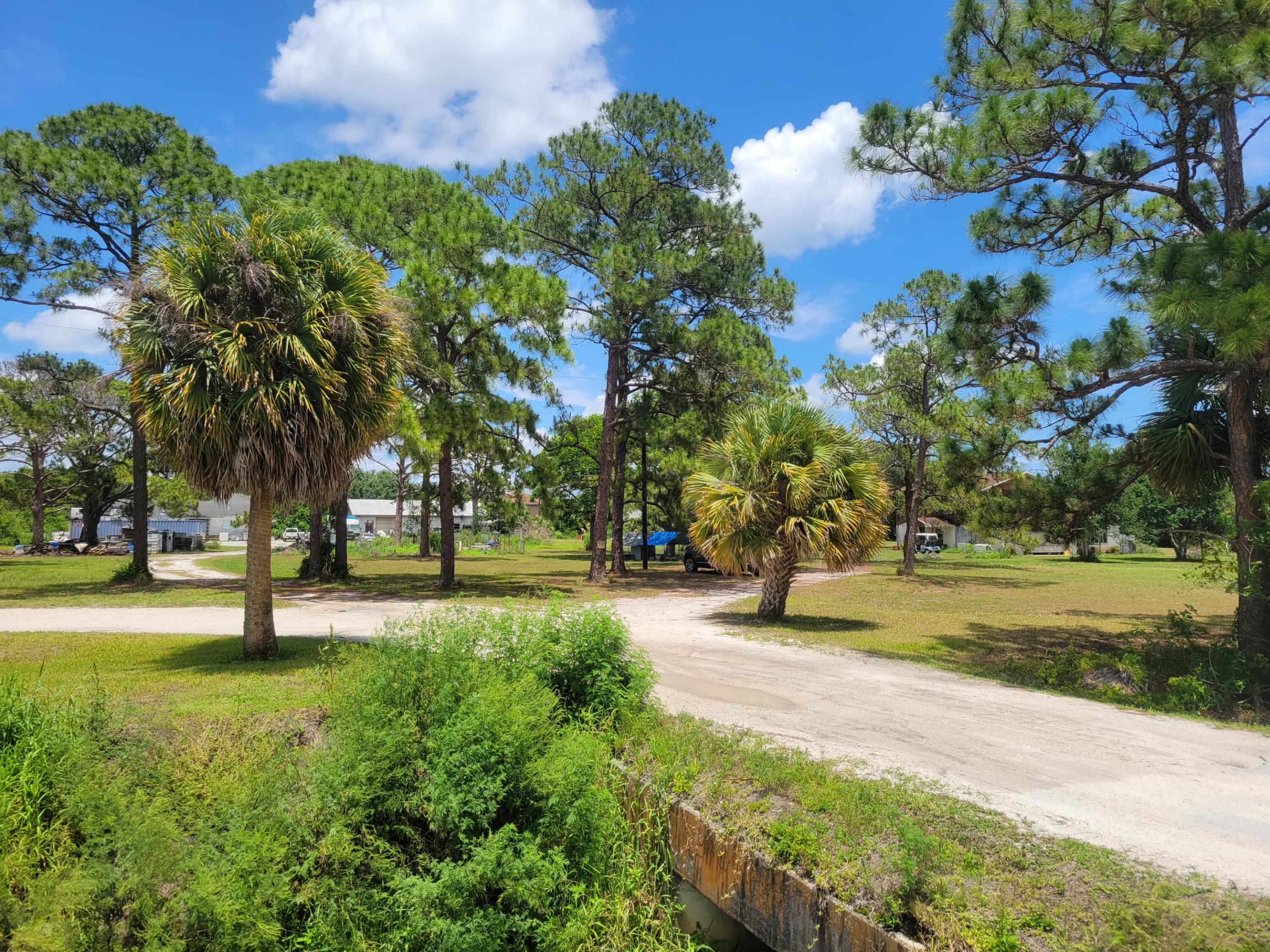 4.85 Acres several hundred ft East of Turnpike overpass on the North side of Orange Ave. House over 2,400 sf with 2 outbuildings each approx 3,000 sf. Zoning AR-1